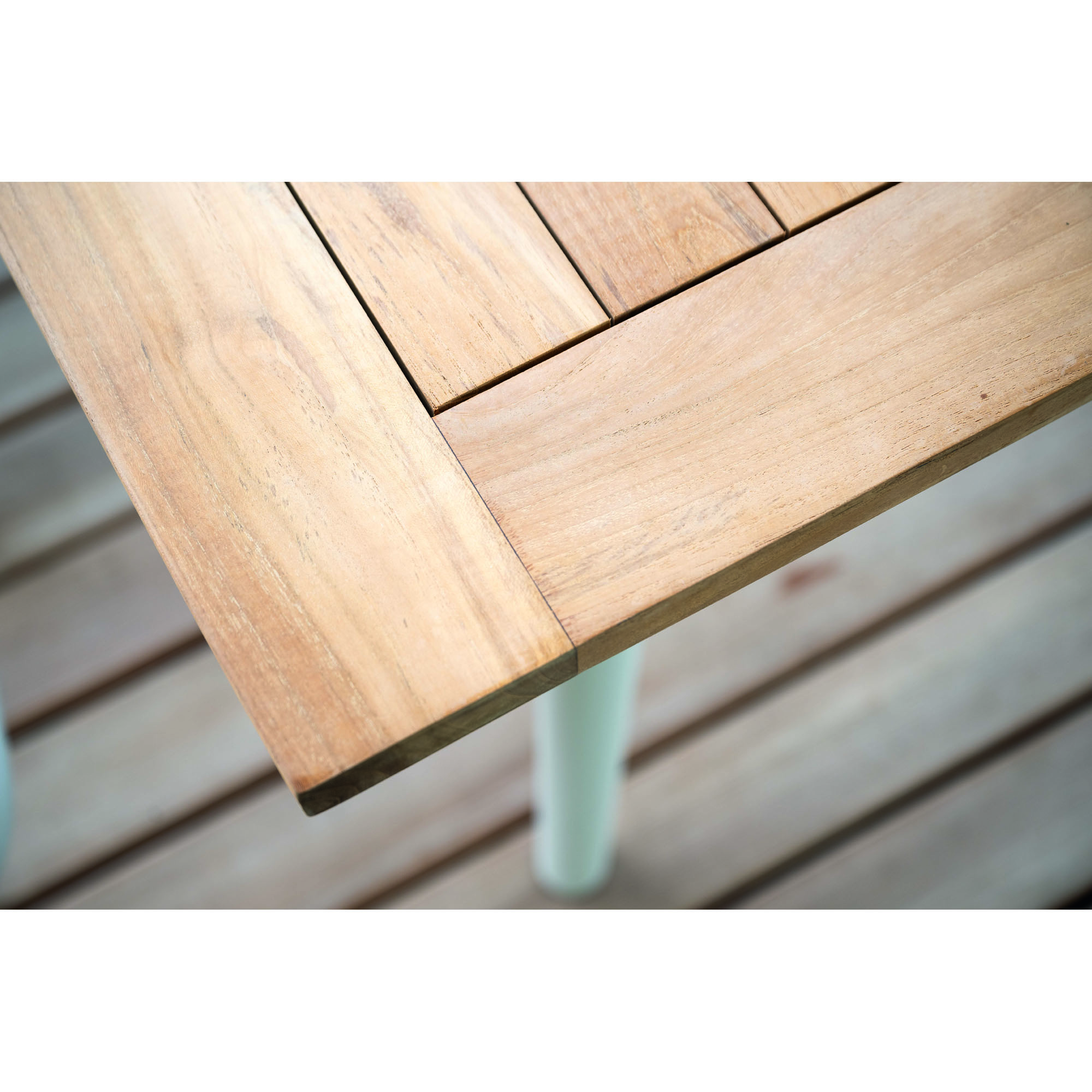 Nahaufnahme der Ecke einer Holz Tischplatte mit sichtbarer Maserung und eingelassenen Leisten