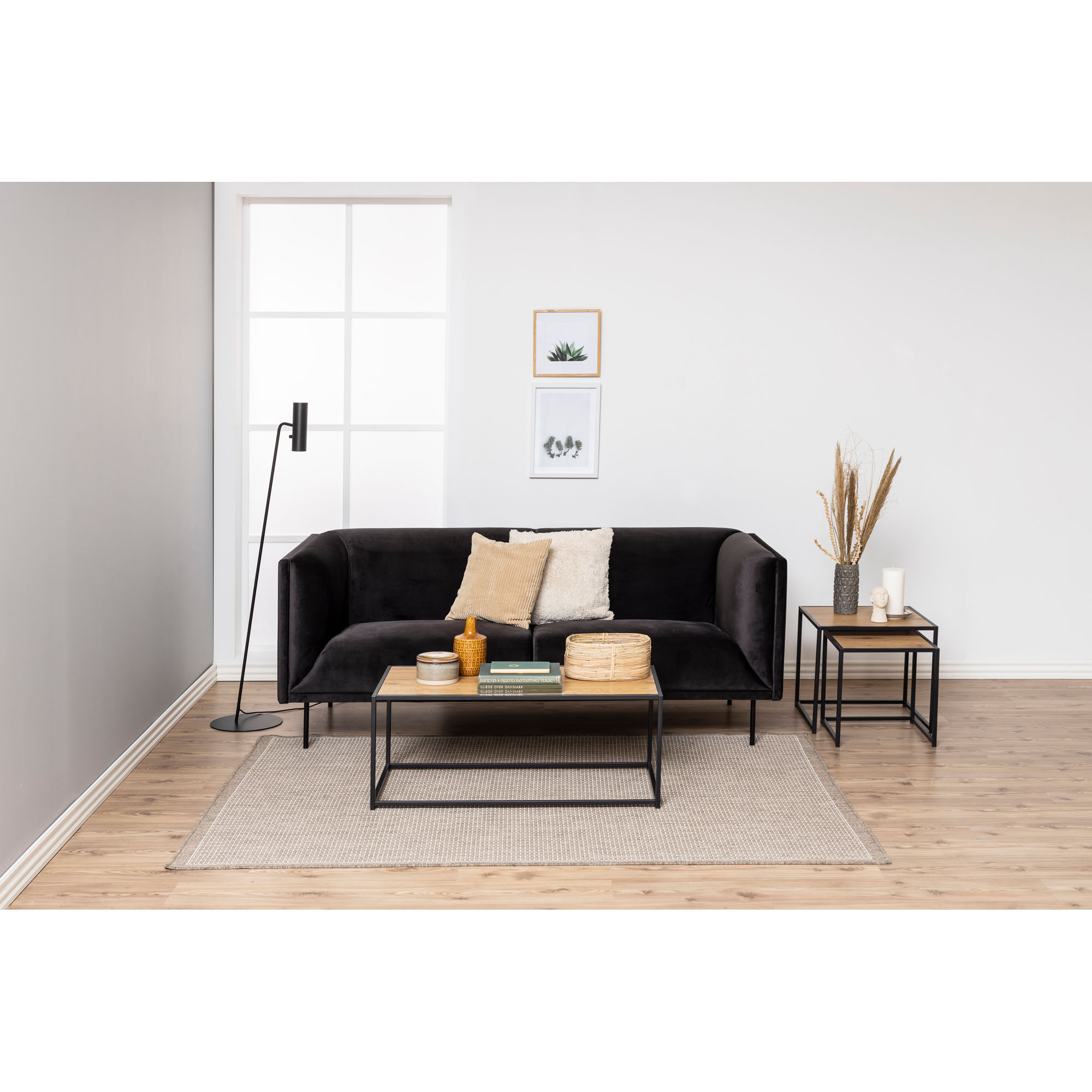Couchtisch mit Platte in Wildeiche und mattschwarzem Gestell in einem eingerichteten Wohnzimmer, dekoriert mit Dekoartikeln und Büchern