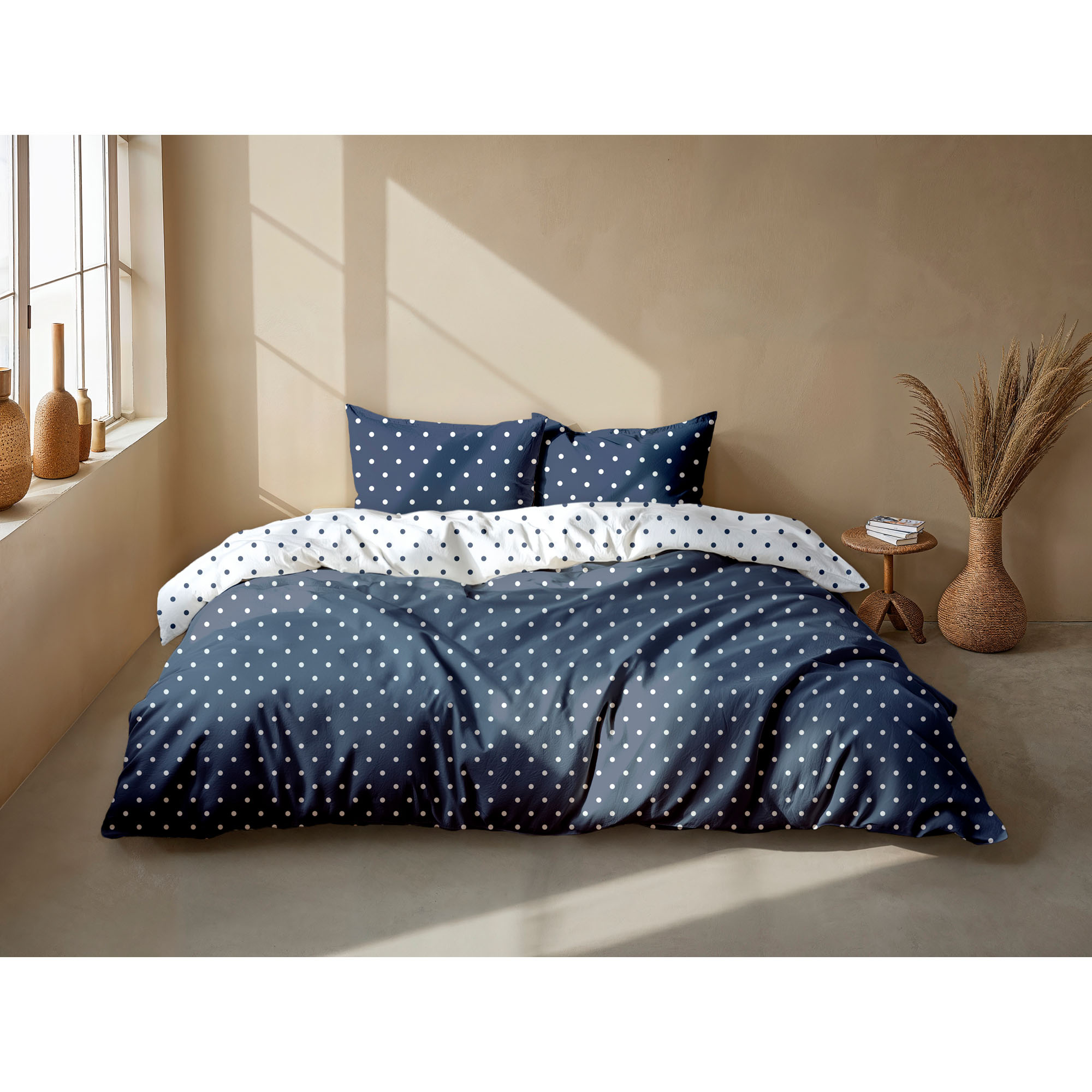 Bettwäsche Punta di Cotone in Maritime Blue, 135 x 200 cm: bezogenes Bett in seitlicher Schlafzimmerszene mit Punktmuster und kontrastierender Wendeseite.