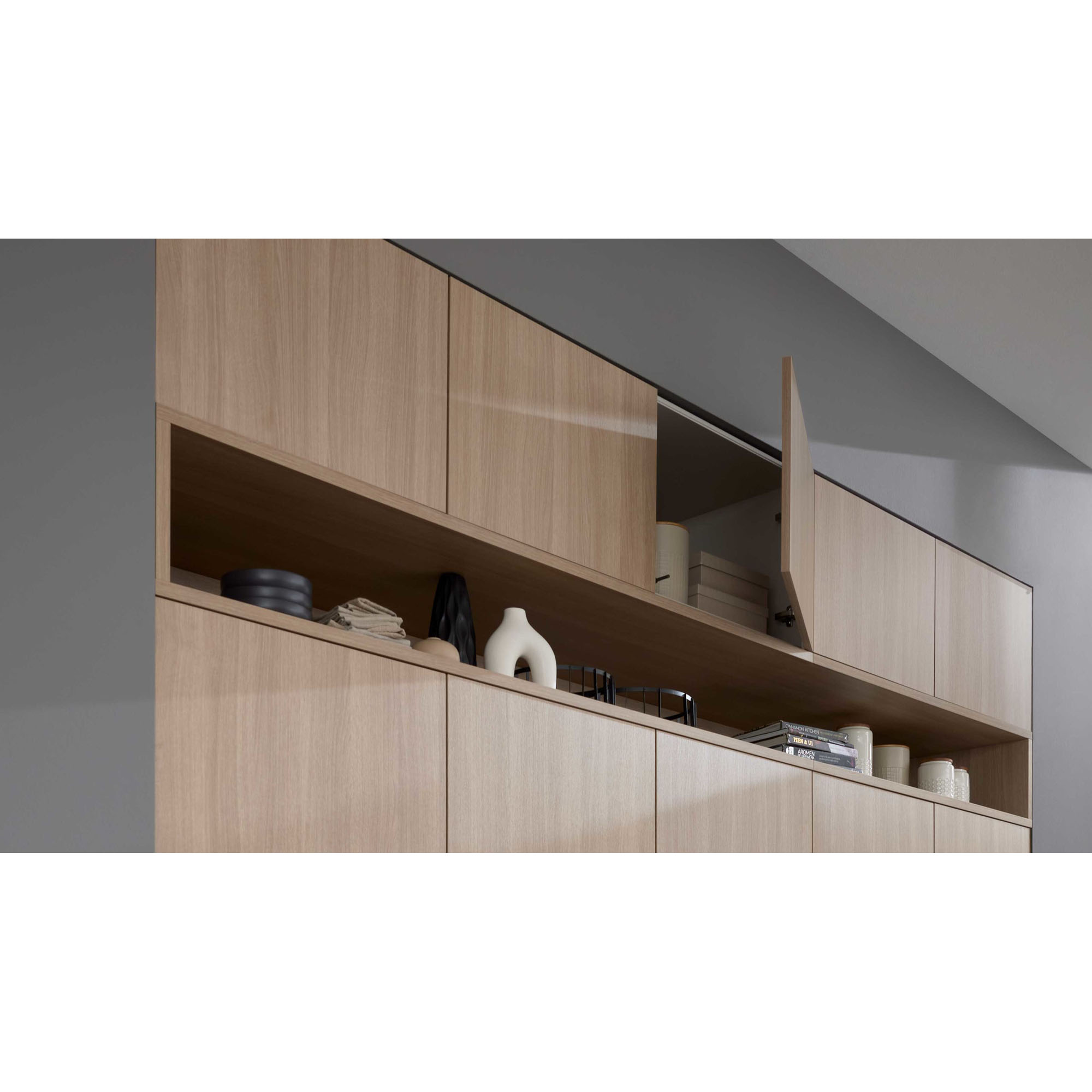 Holzfarbene Oberschrankzeile einer modernen Küche mit geöffnetem Klappenschrank und Dekoartikeln.