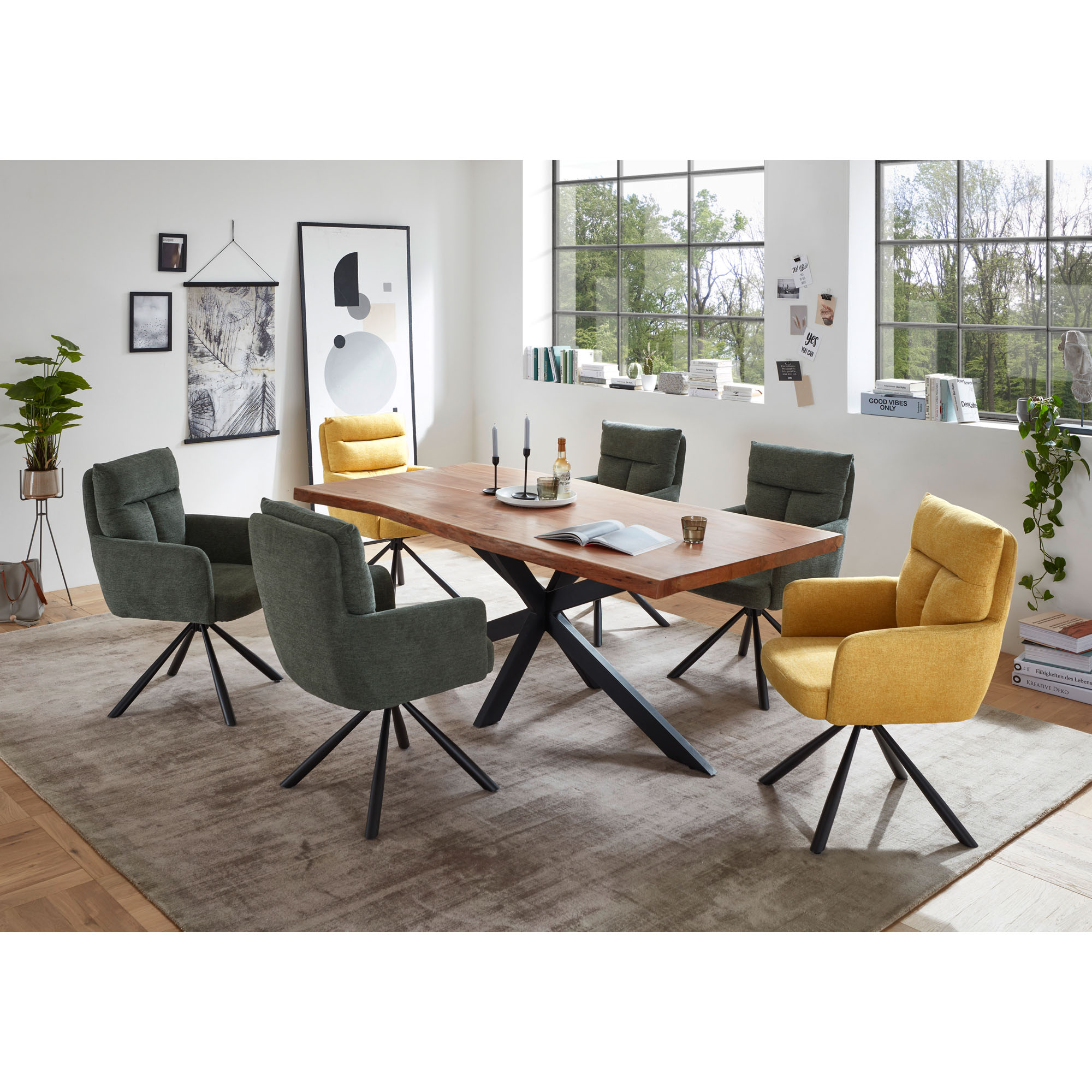 Esszimmer mit Holztisch und mehreren Polsterstühlen mit schwarzem Gestell, darunter zwei Stühle in gelb