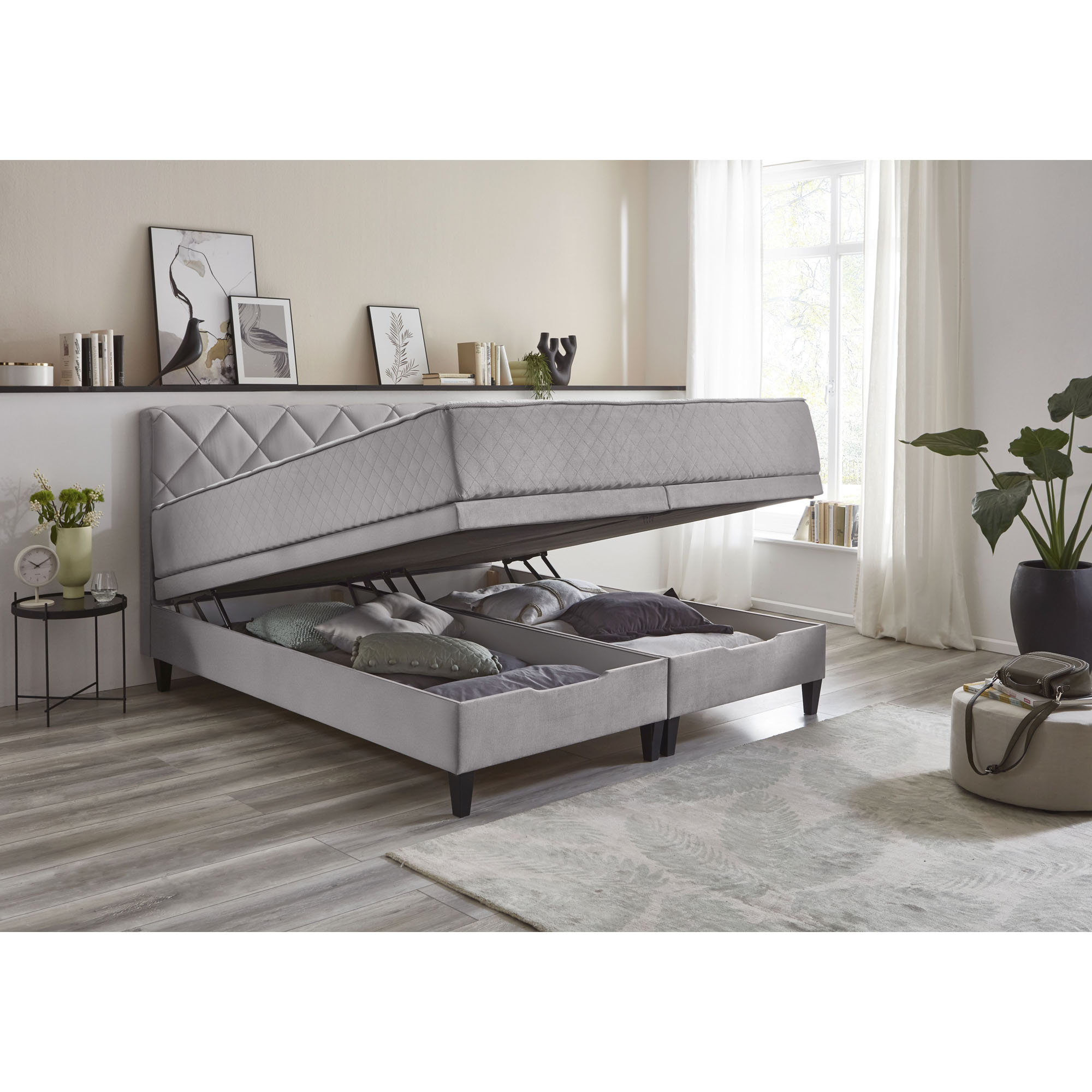 Boxspringbett mit hochgeklappter Liegefläche und sichtbarem Bettkasten zur Aufbewahrung