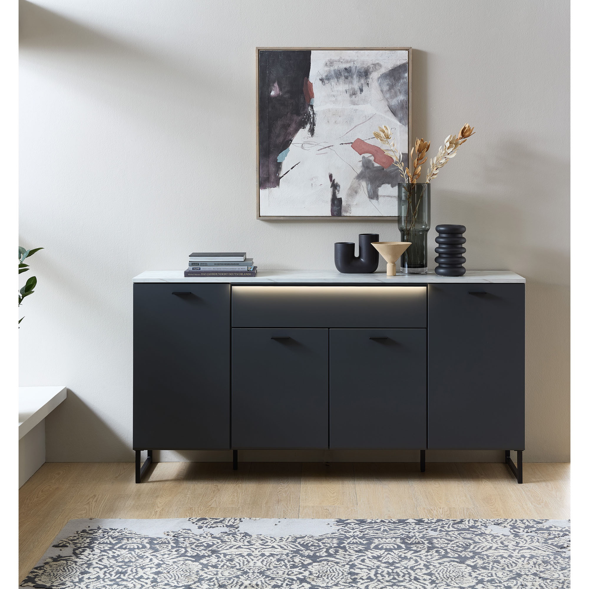 Sideboard in Anthrazit mit Marmoroptik und integrierter LED-Beleuchtung dekoriert in einem modernen Wohnraum.