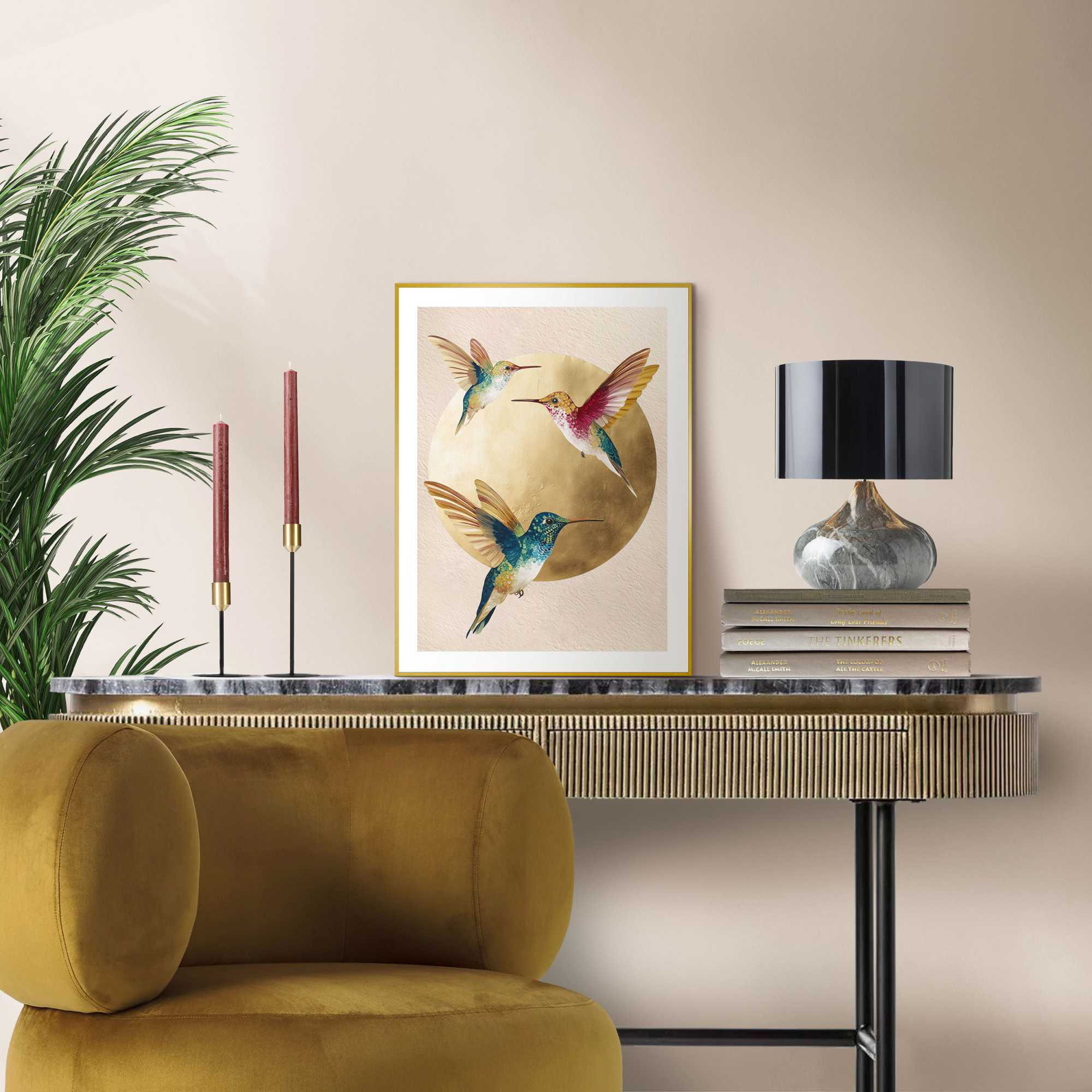 Das Wandbild „Dancing Hummingbirds“ in Gold, 30 × 40 cm, hängt in einem eingerichteten Wohnraum und zeigt die Größenwirkung an der Wand.