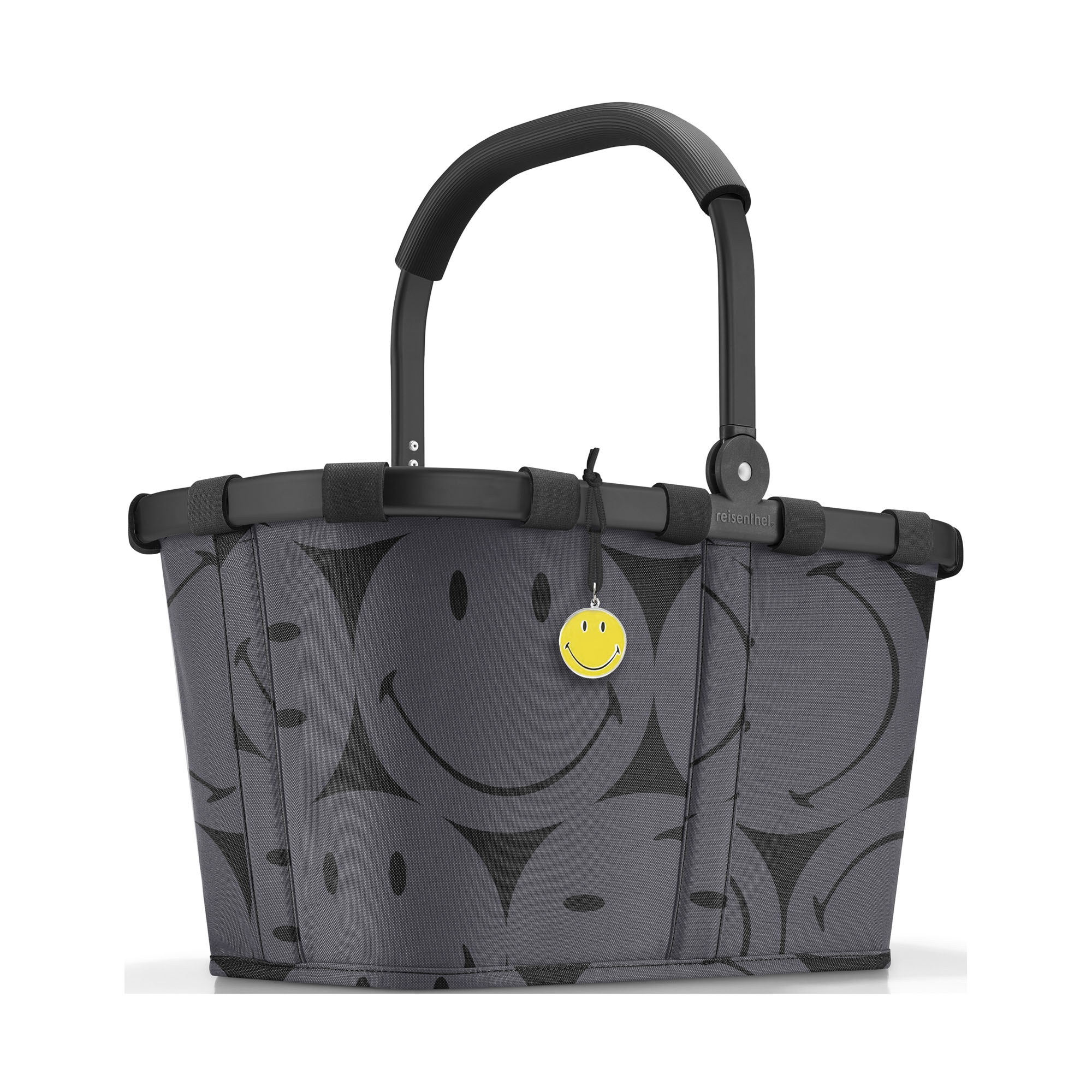 Einkaufskorb von Reisenthel, Modell Carrybag, in Grau mit großflächigem Smiley-Muster, frontal mit hochgestelltem Griff und gelbem Smiley-Anhänger.