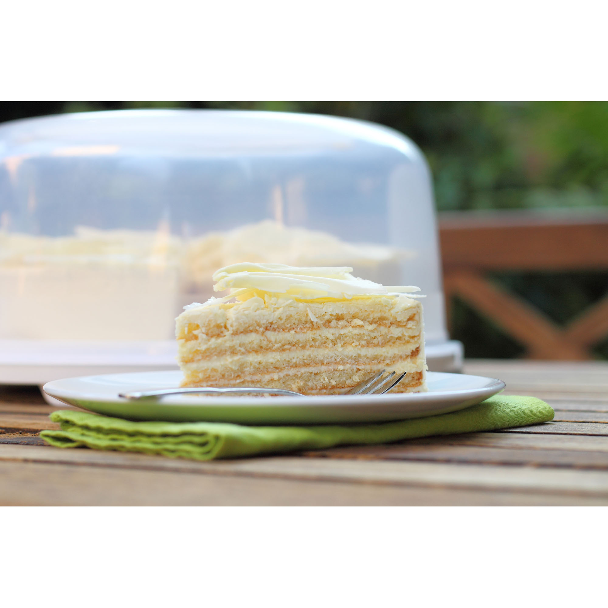 Transparente Kuchenhaube auf einem Unterteller mit einer Torte darunter