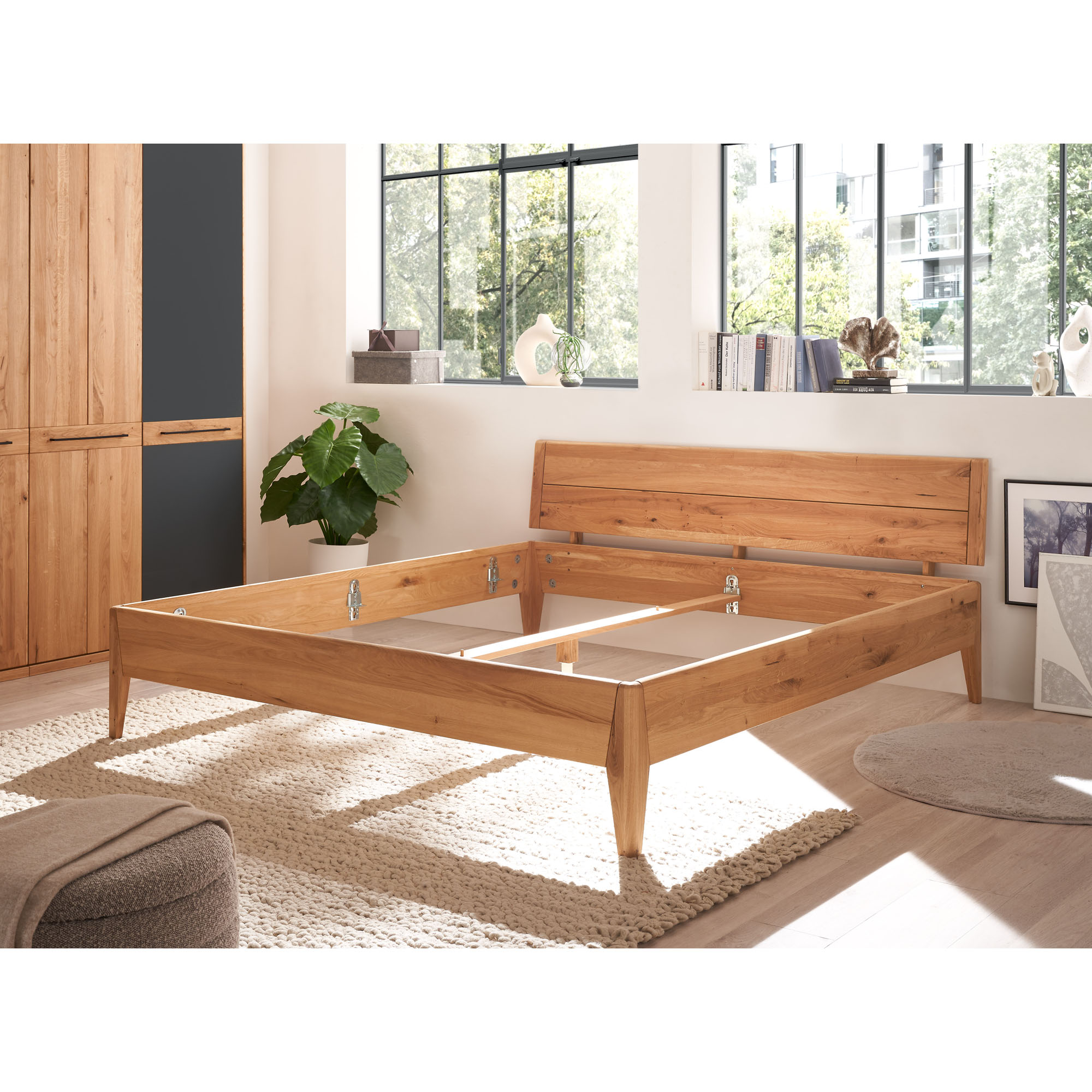 Bettgestell aus Holz ohne Matratze in einem modern eingerichteten Schlafzimmer
