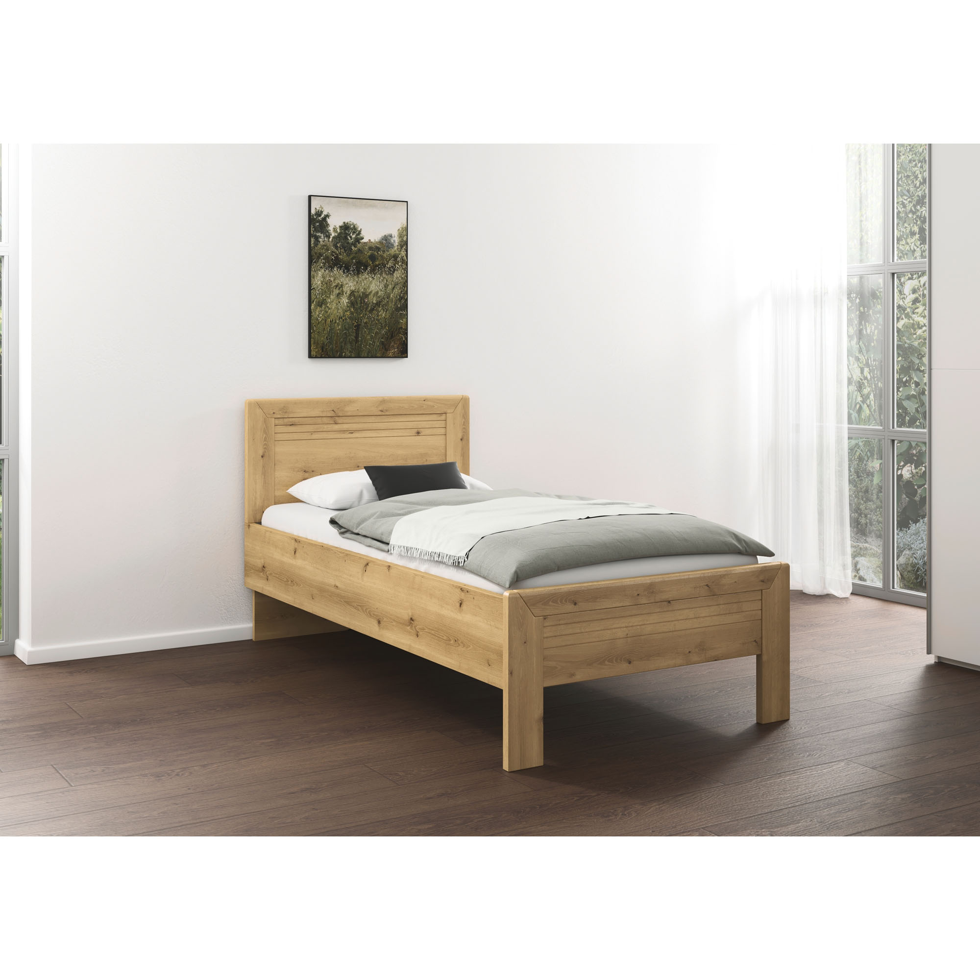 Holzbett in Eicheoptik mit grauer Bettdecke und Kissen in einem hellen Schlafzimmer mit großen Fenstern