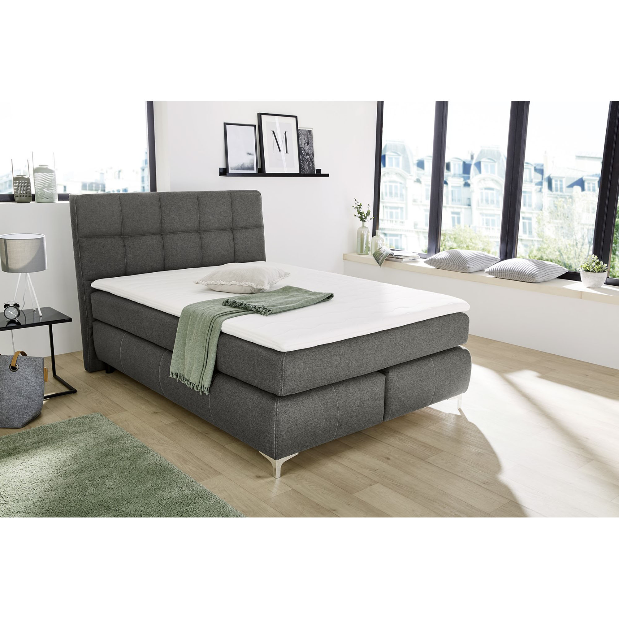 Boxspringbett mit Liegefläche 140×200 cm in Grau, dargestellt in einem Milieubild in einem Schlafzimmer