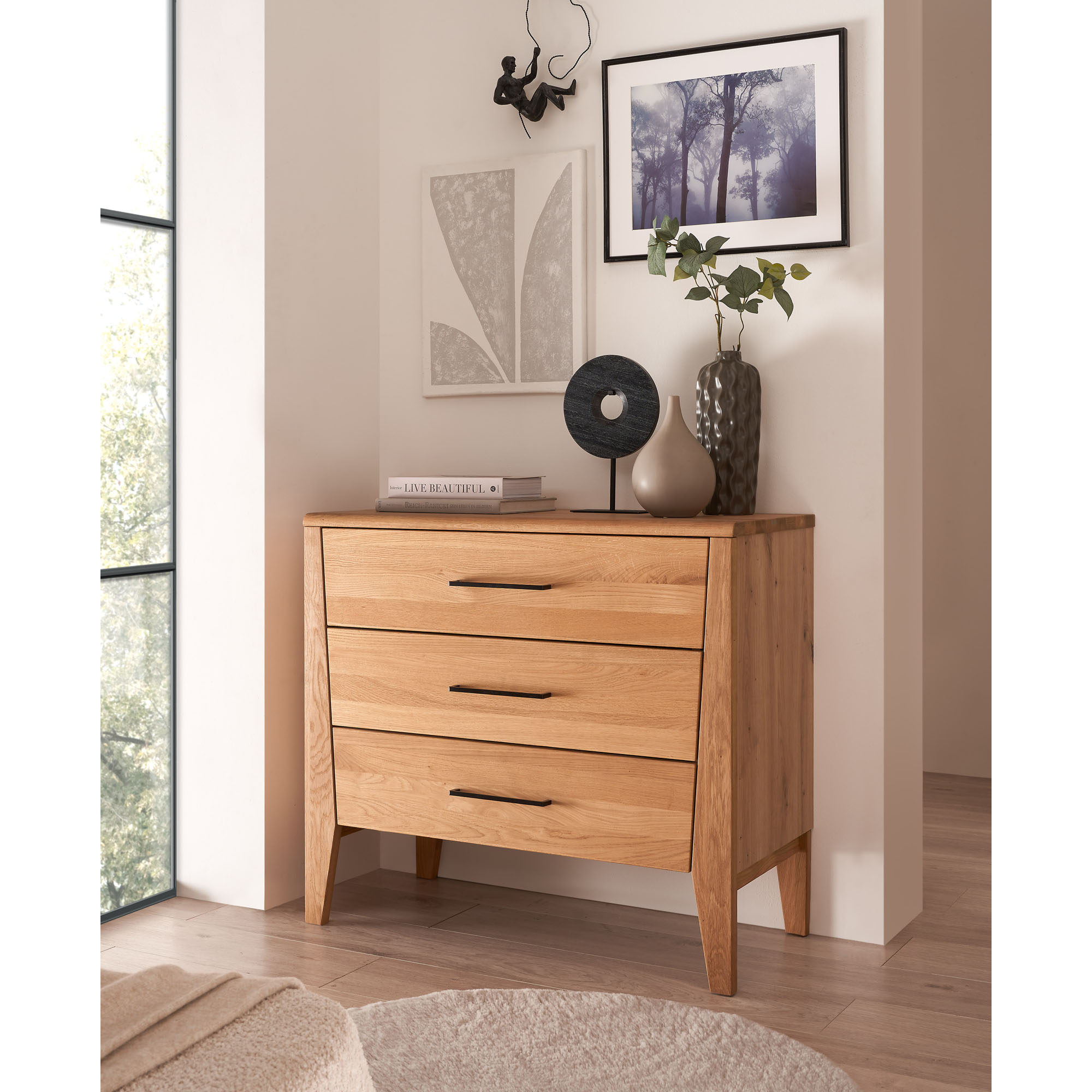 Kommode aus Holz mit drei Schubladen vor einer Wand im Schlafzimmer