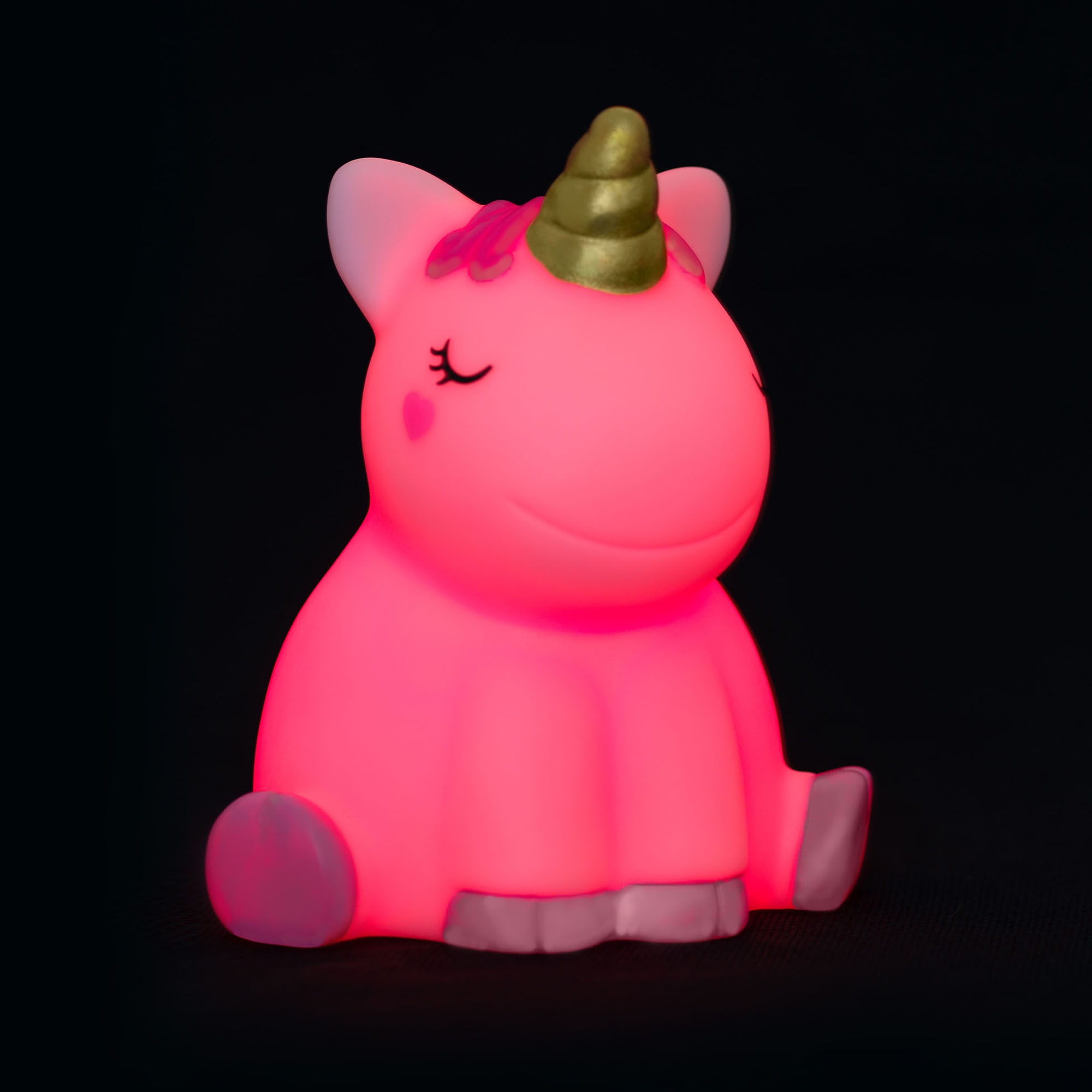 Nachtlicht in Einhornform, vor schwarzem Hintergrund rosa bis rot leuchtend gezeigt.