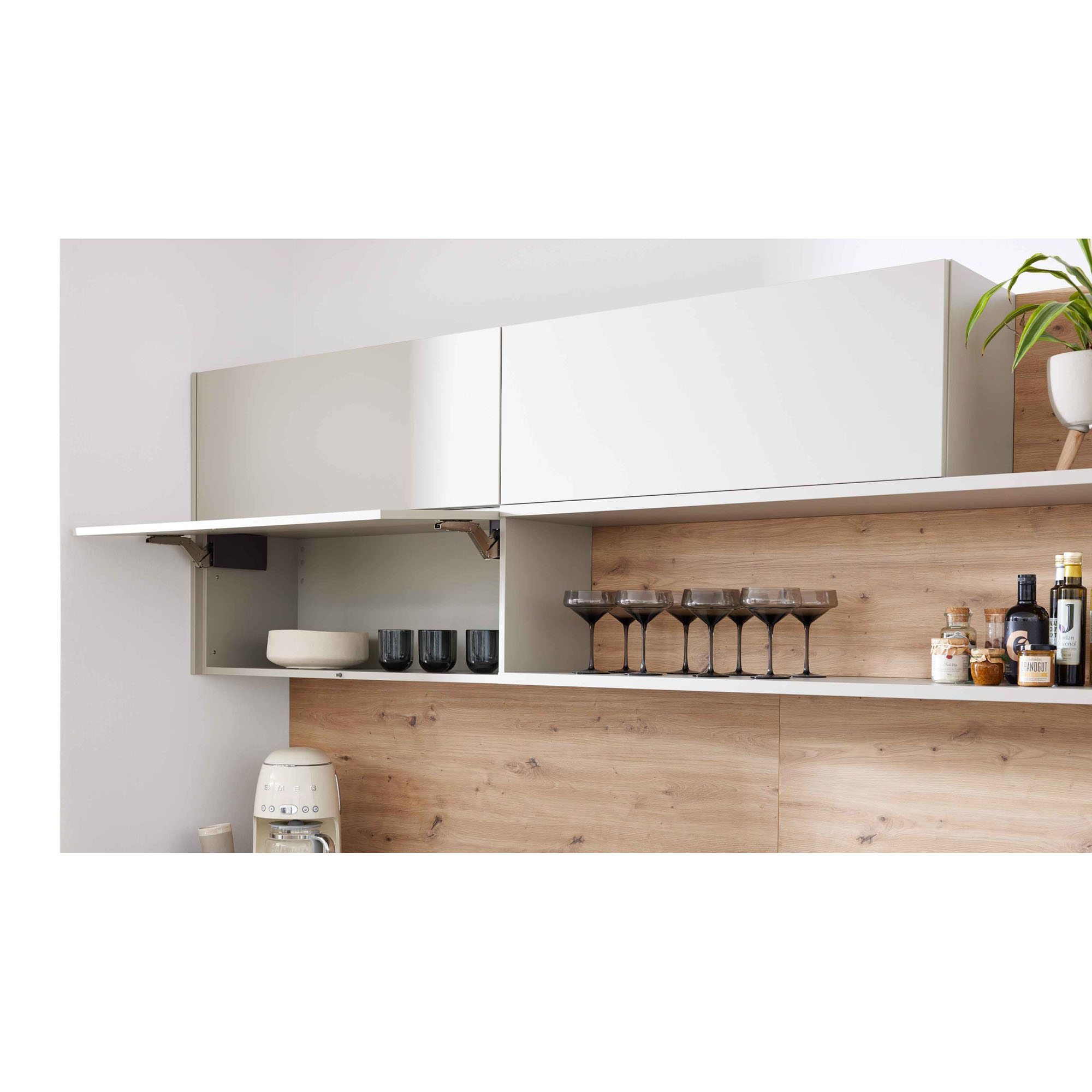 geöffnete Hängeschränke in moderner Küche mit Gläsern und Schalen auf Holzrückwand
