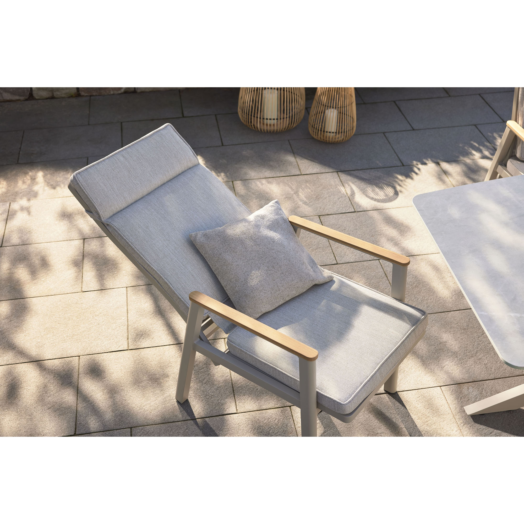 Gartenstuhl mit Polster auf einer Terrasse neben einem Gartentisch