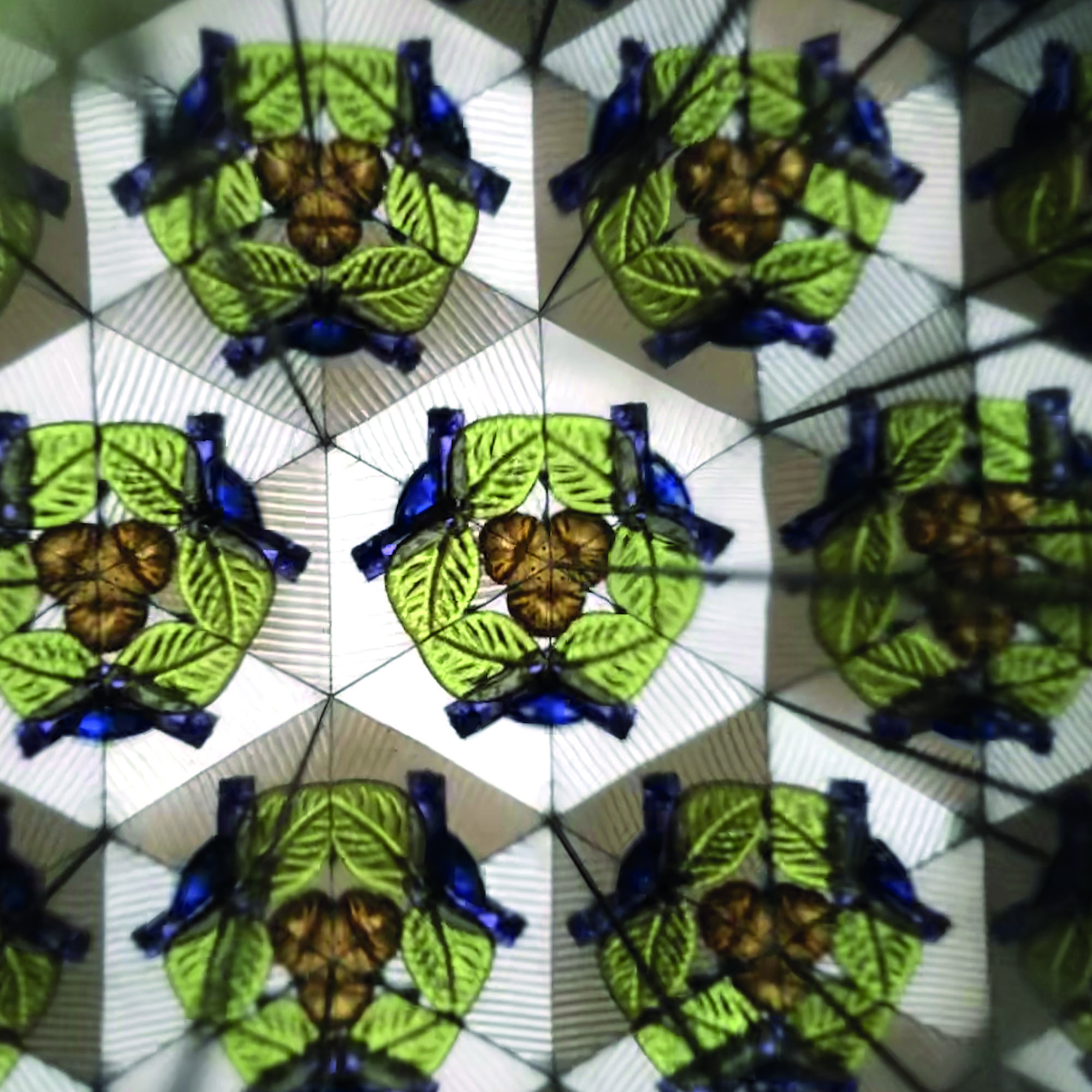 Blaues Kaleidoskop mit Weltraummotiv, mit einem symmetrischen bunten Muster aus mehrfach gespiegelten Figuren gezeigt.