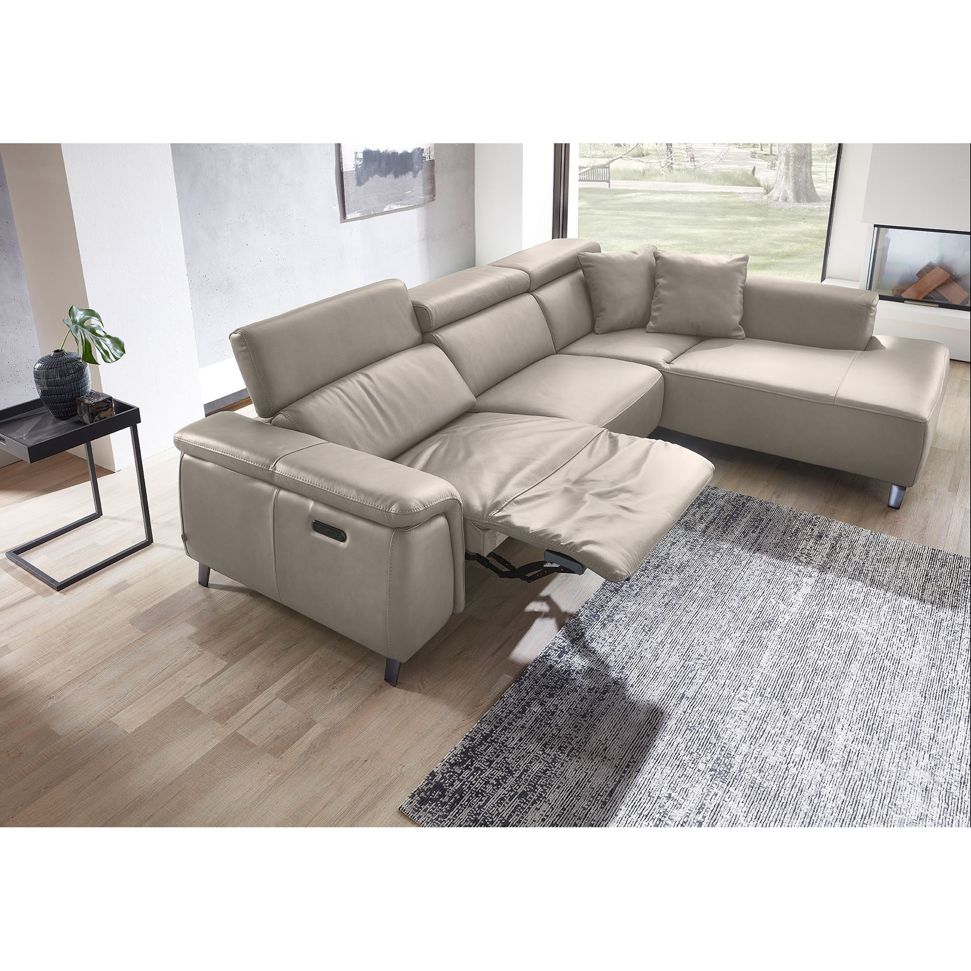 Beiges Ecksofa mit ausgefahrener Relaxfunktion und verstellbarer Rückenlehne auf Teppich im Wohnraum