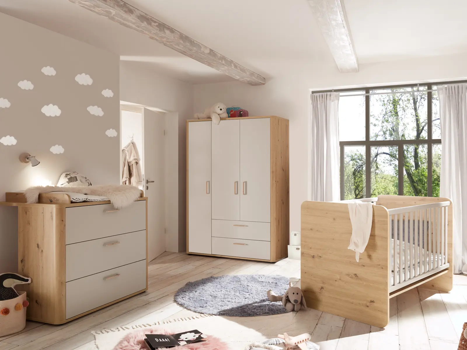 Freundlich gestaltetes Babyzimmer mit Kinderbett, Kleiderschrank, Kommode und Fensterfront