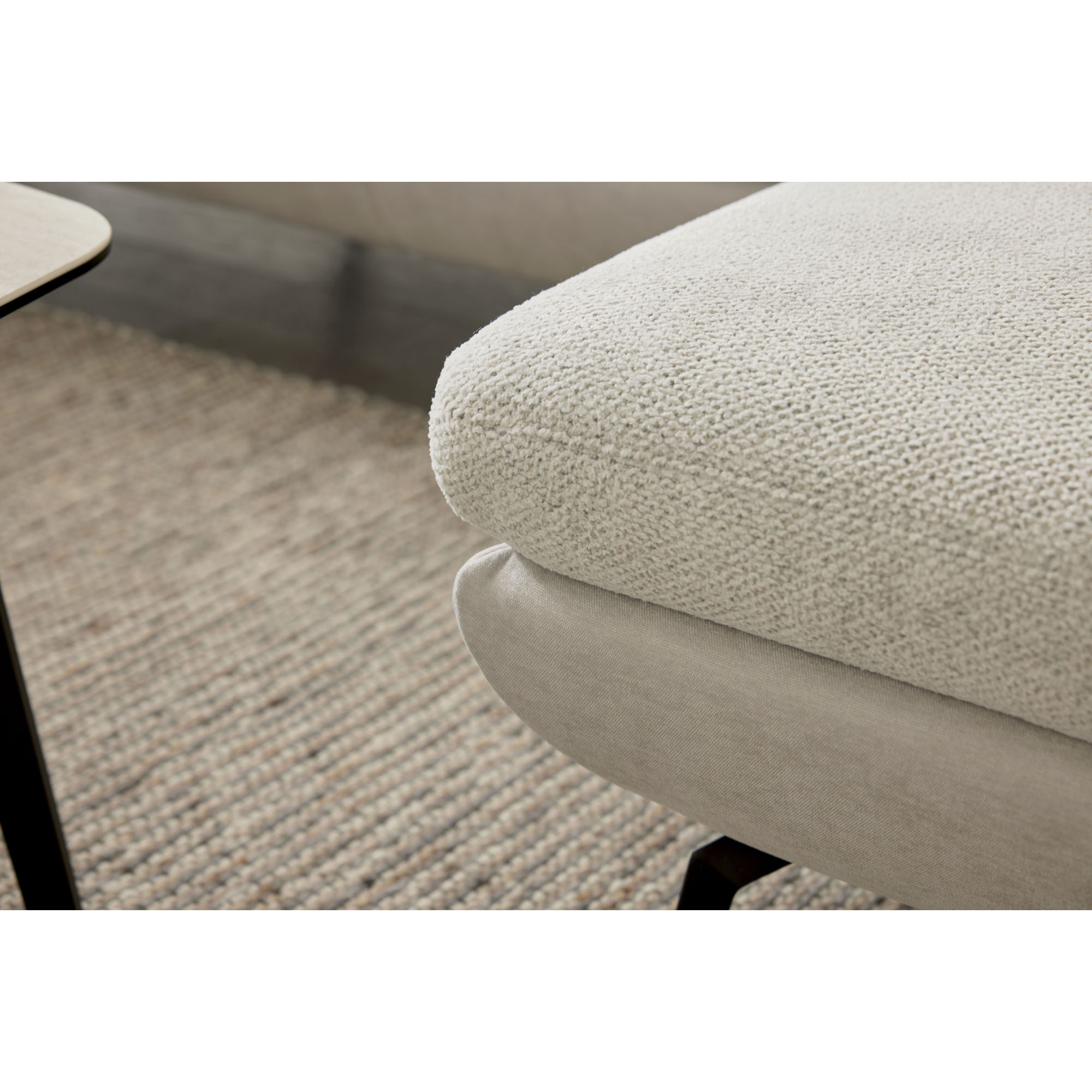 Detail der abgerundeten Sitzfläche der Interliving Sofa Serie 4304 über einem Teppich