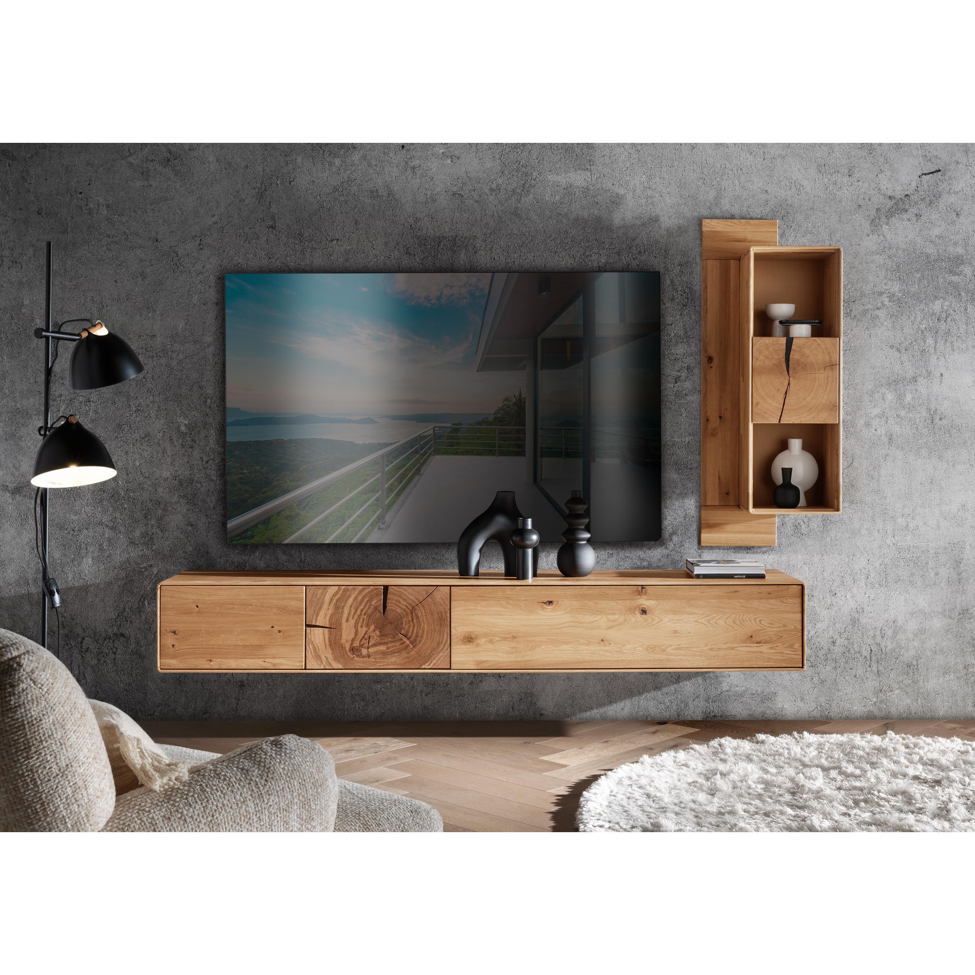 Wohnwand aus Holz mit Lowboard Hängeregal und Fernseher an einer Wand in einem Wohnzimmer mit Sofa und Dekoration