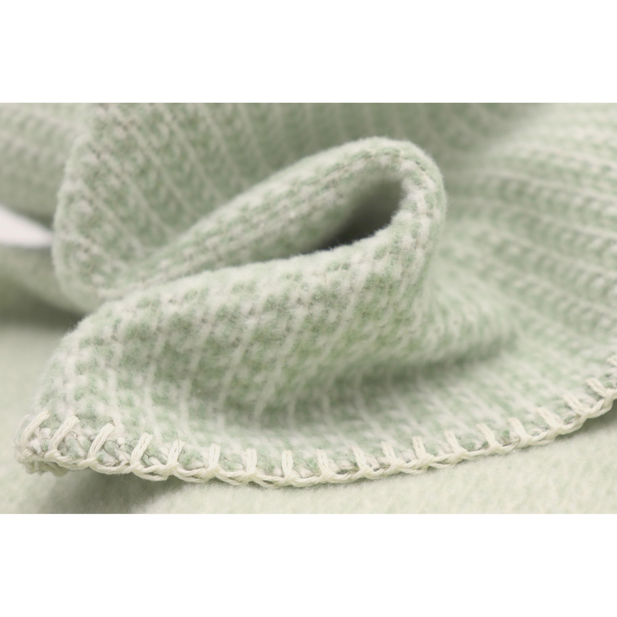 Nahaufnahme der Babydecke Cotton green mit weicher Stofffalte und fein umketteltem Rand.