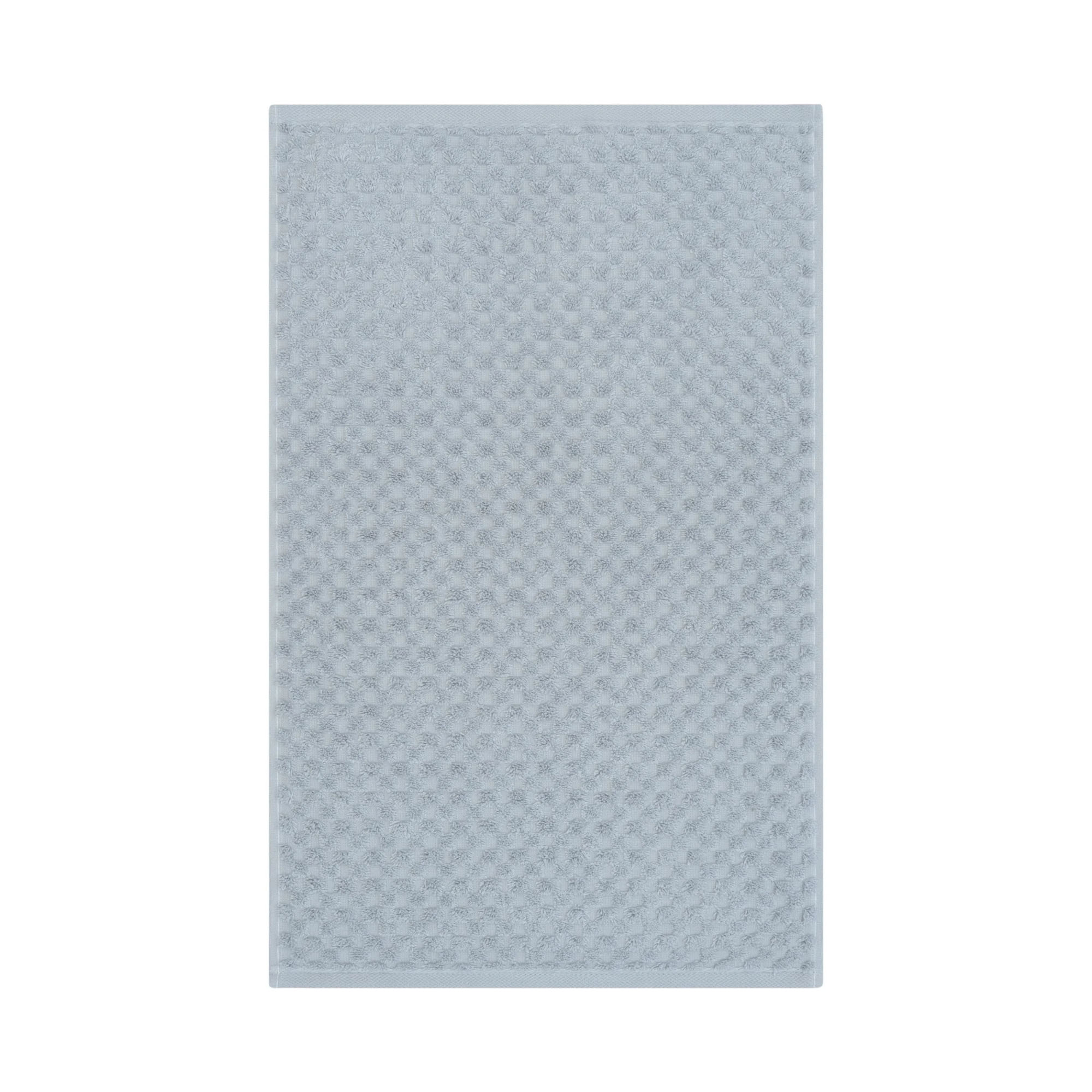 Handtuch in der Farbe Sturmblau, flach auf weißem Hintergrund gezeigt; die fein geometrisch strukturierte Oberfläche ist über die gesamte Fläche sichtbar.
