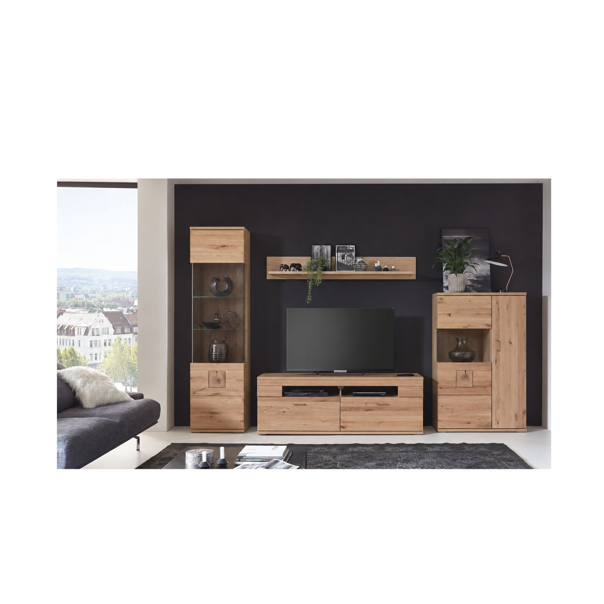 Wohnkombination in Holzoptik mit Fernseher, Schrankelementen, offenen Ablagefächern und Dekoration vor einer dunklen Wand