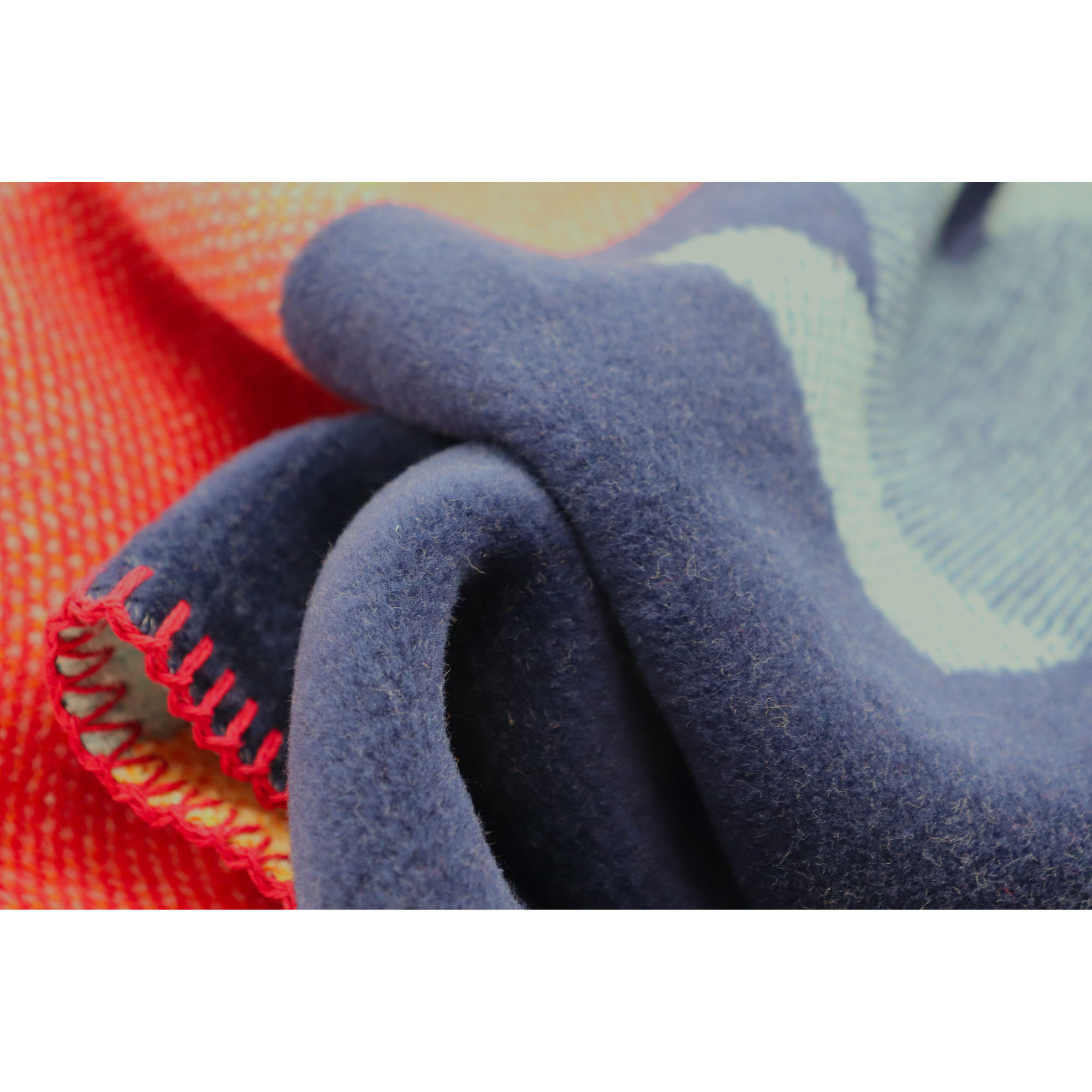 Nahaufnahme der Babydecke Little Rocket mit dunkelblauer Stofffalte, rotem Rand und hellblauem Motivbereich.