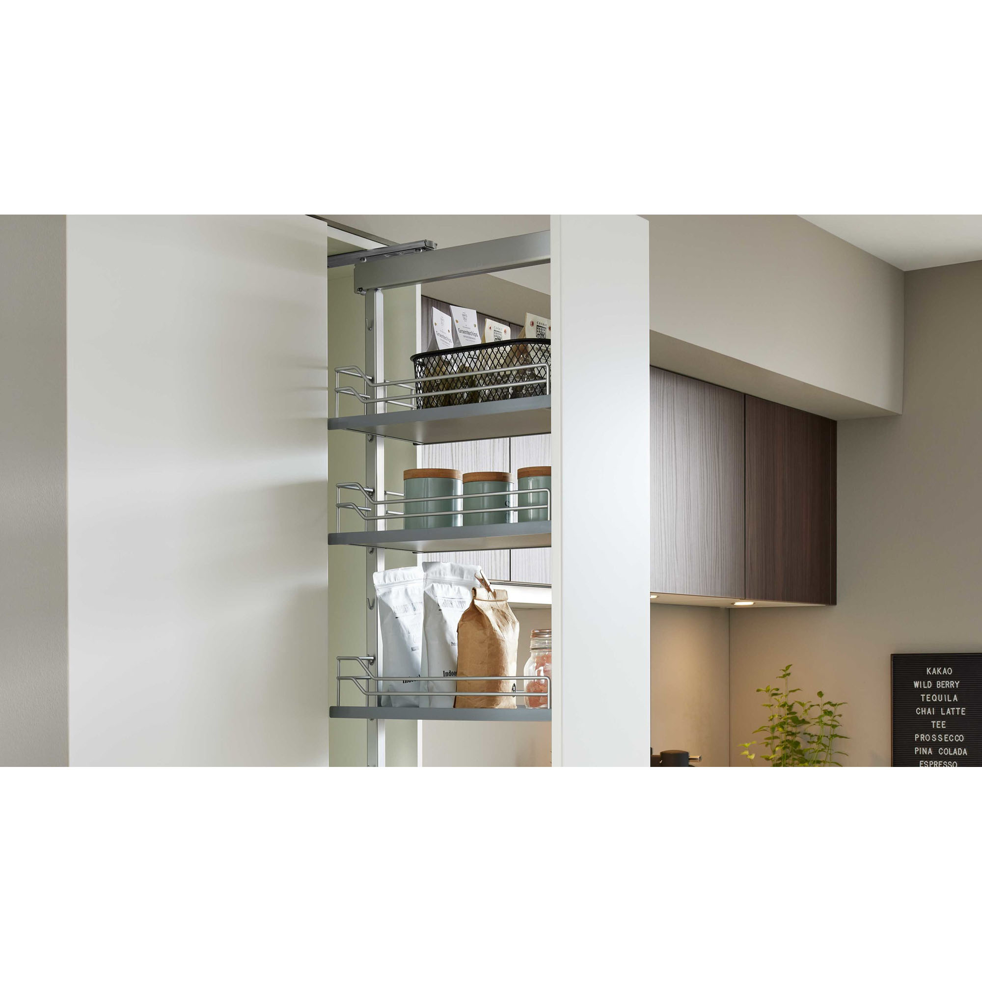 Geöffneter Hochschrank mit ausziehbaren Regalen, gefüllt mit Vorratsdosen, Kaffeepackungen und einem Drahtkorb in einer modernen Küche