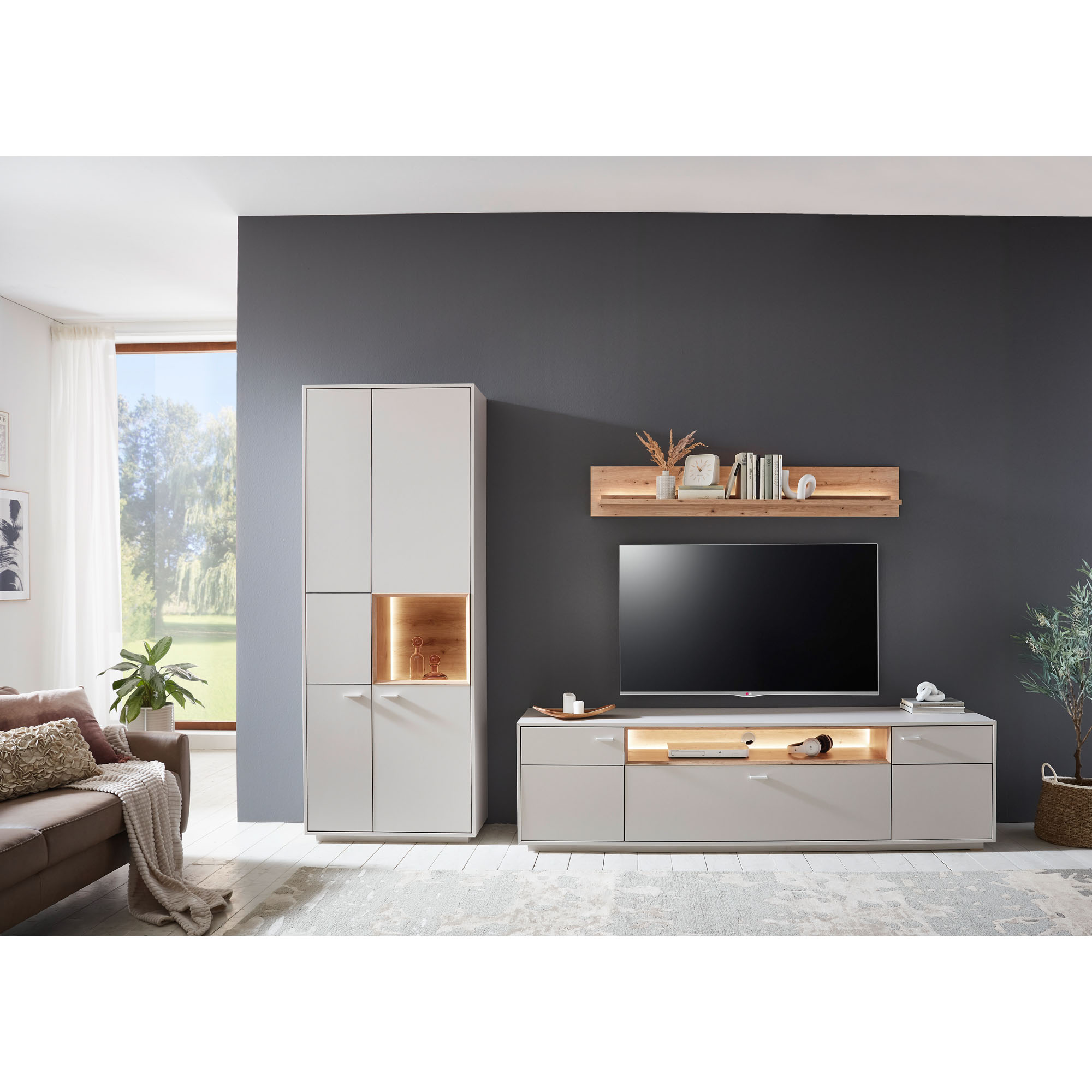 Wohnkombination mit Hochschrank TV-Lowboard und Wandregal in einem hell eingerichteten Wohnzimmer