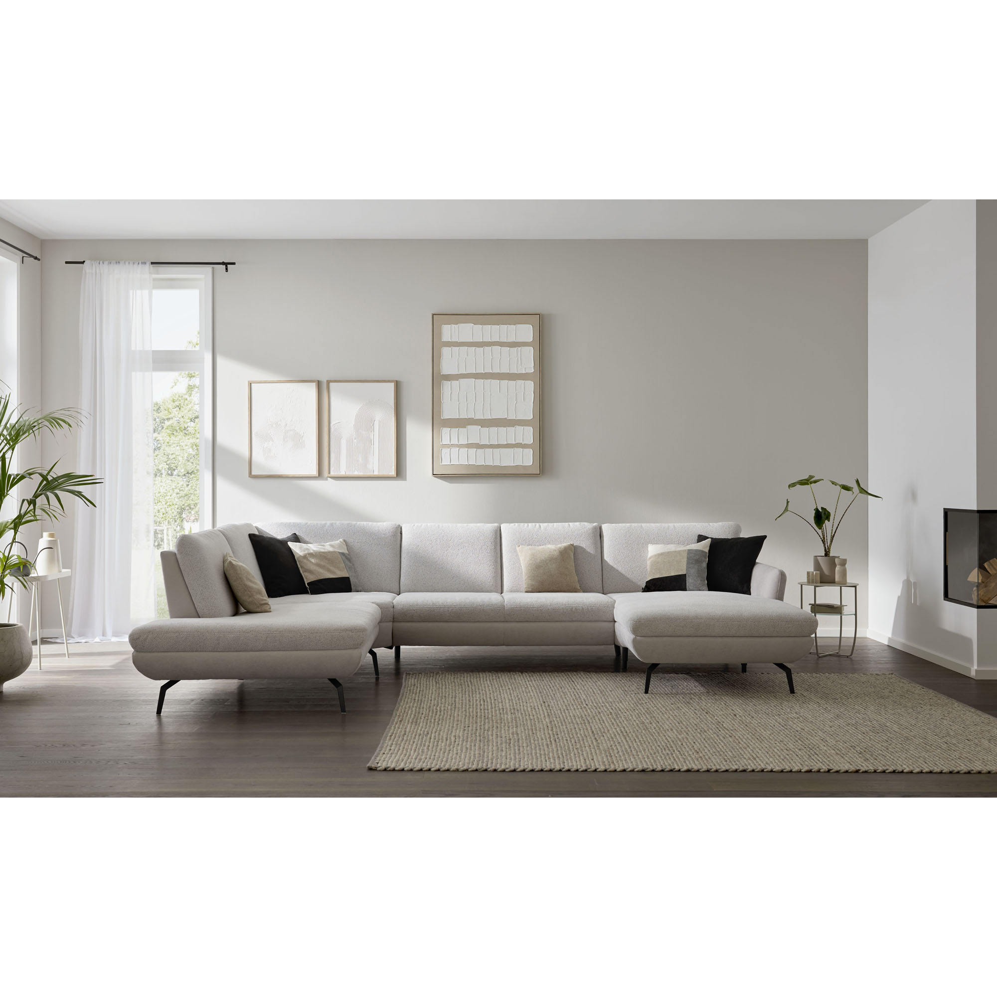 Wohnlandschaft Interliving Sofa Serie 4304 in hellem Wohnzimmer mit Teppich und Wandbildern