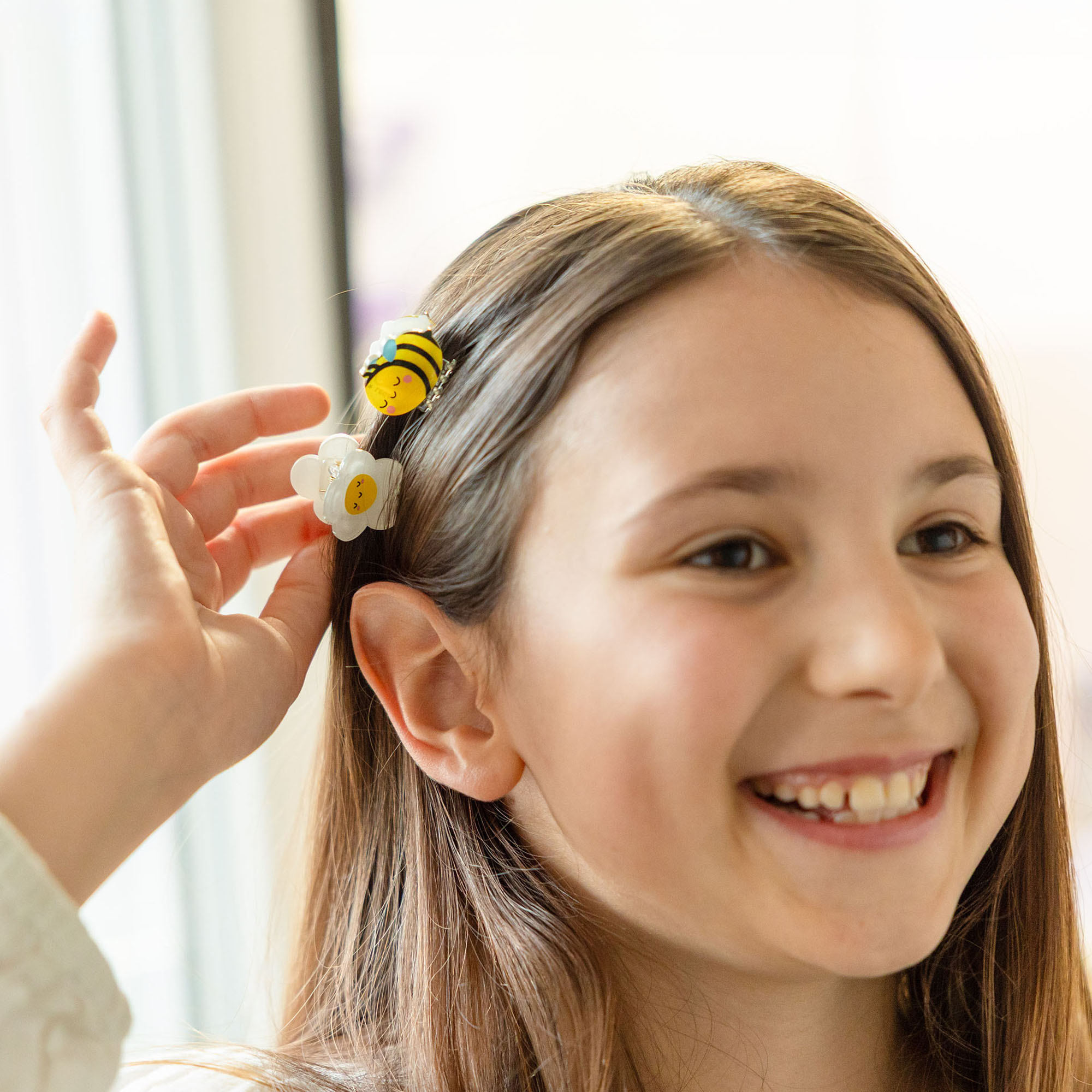 Haarspangen-Set, 4 Stück – Biene von Legami: Kind trägt gelbe Bienen-Haarspange im Haar.