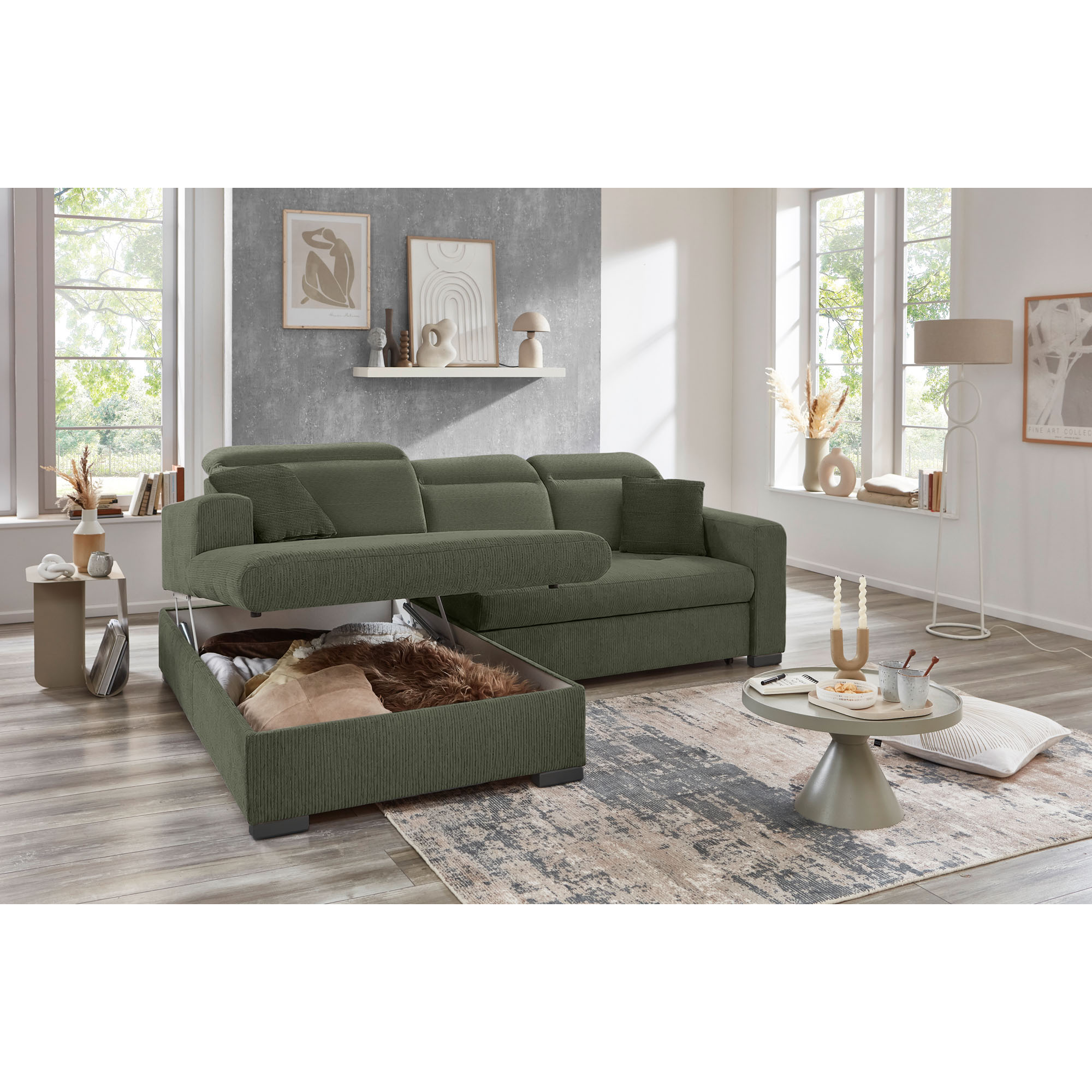 Grünes Ecksofa mit Ottomane links und geöffnetem Bettkasten in einem modern eingerichteten Wohnzimmer