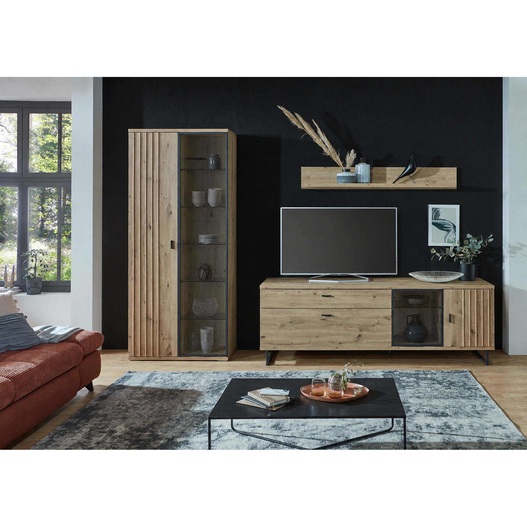 Moderne Wohnkombination mit Hochschrank TV-Lowboard und Wandregal in einem eingerichteten Wohnzimmer