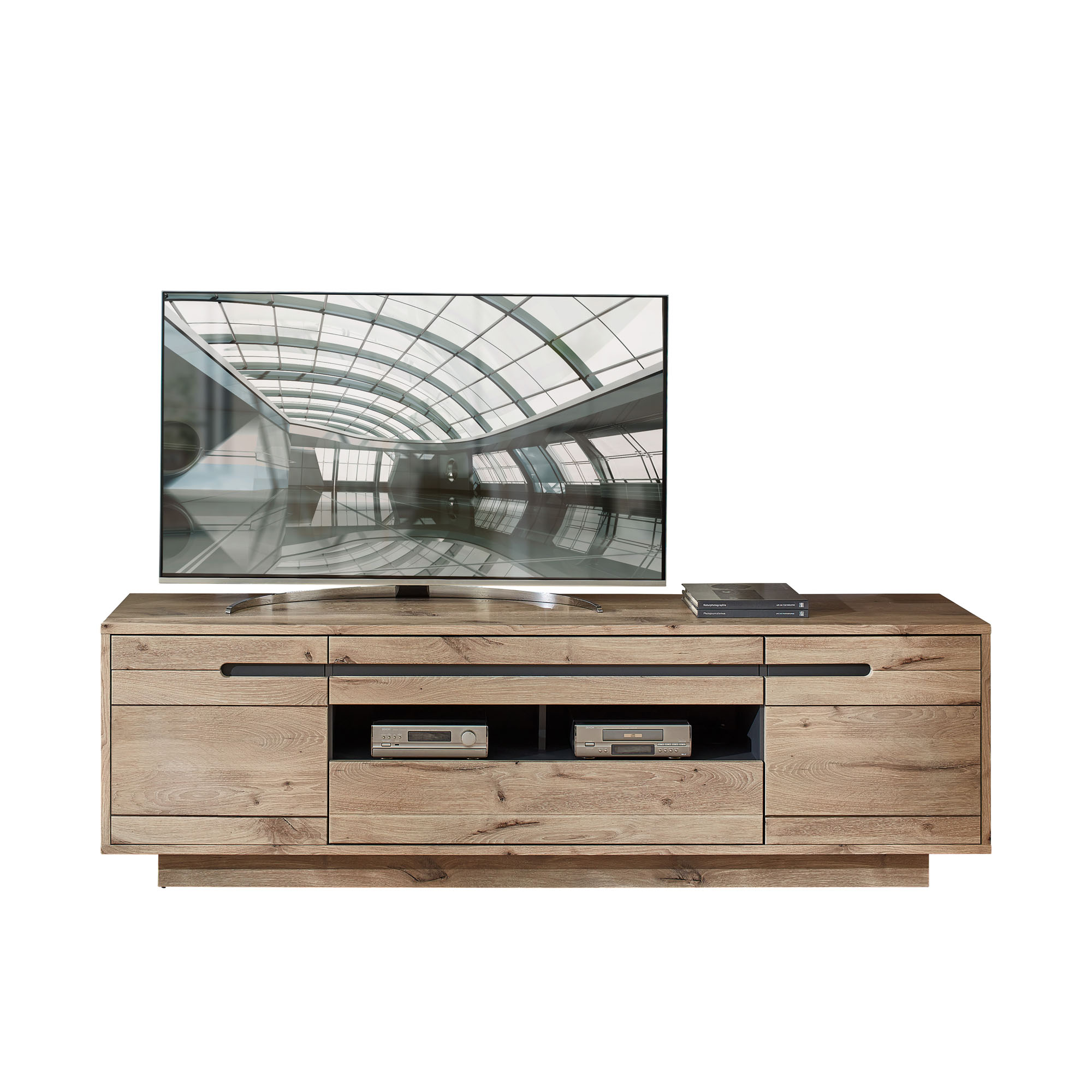 Ein TV-Lowboard in Holzoptik. Auf dem Lowboard steht ein großer Fernseher, daneben liegen zwei Bücher. In der Mitte befinden sich offene Fächer mit zwei Geräten.