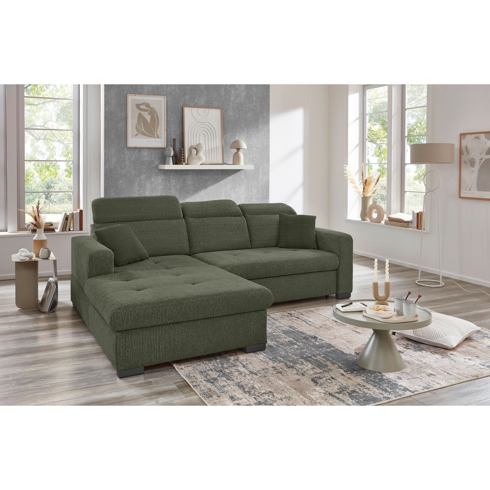 Grünes Ecksofa mit Ottomane links, verstellbaren Kopfstützen und Zierkissen in einem hellen modernen Wohnzimmer