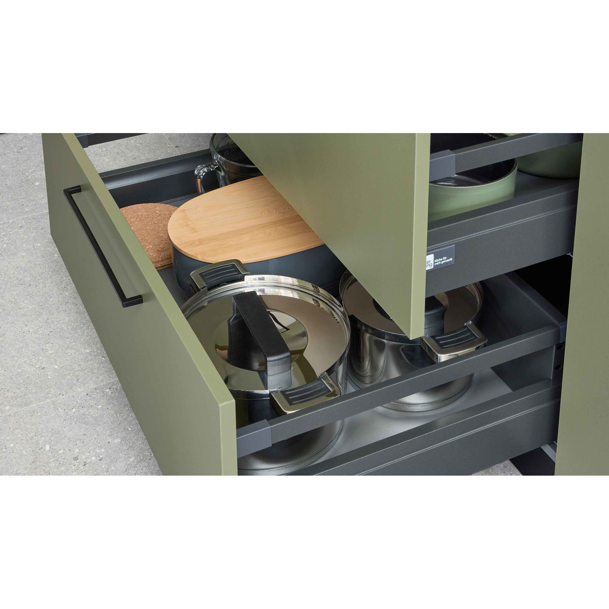 Geöffnete Küchenschubladen mit Töpfen, Pfannen und Küchenutensilien in einer Schubladenorganisation