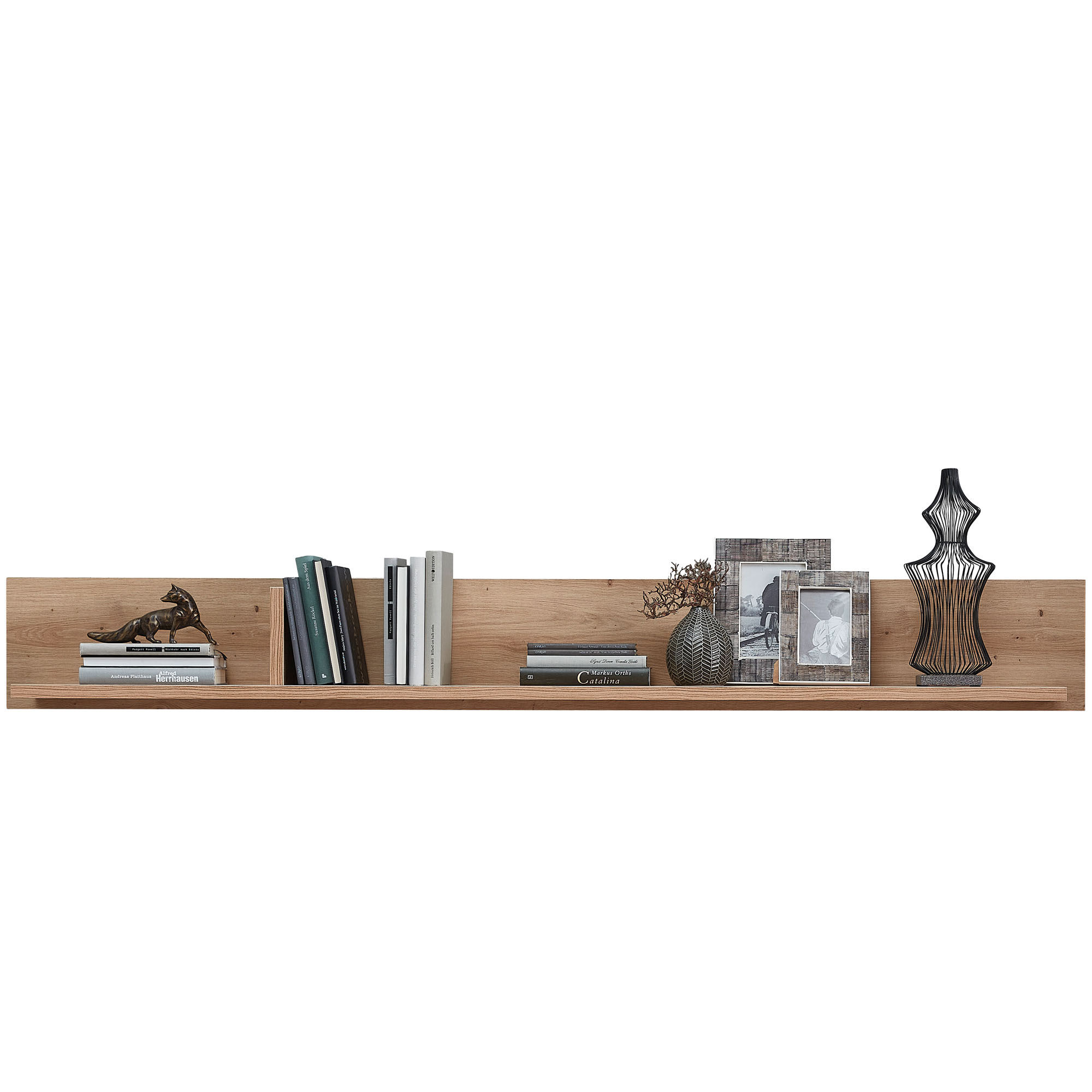 Wandboard aus hellem Holz mit Büchern, Bildern, einem Dekoobjekt und einer Vase mit Trockenblumen, frontal aufgenommen.