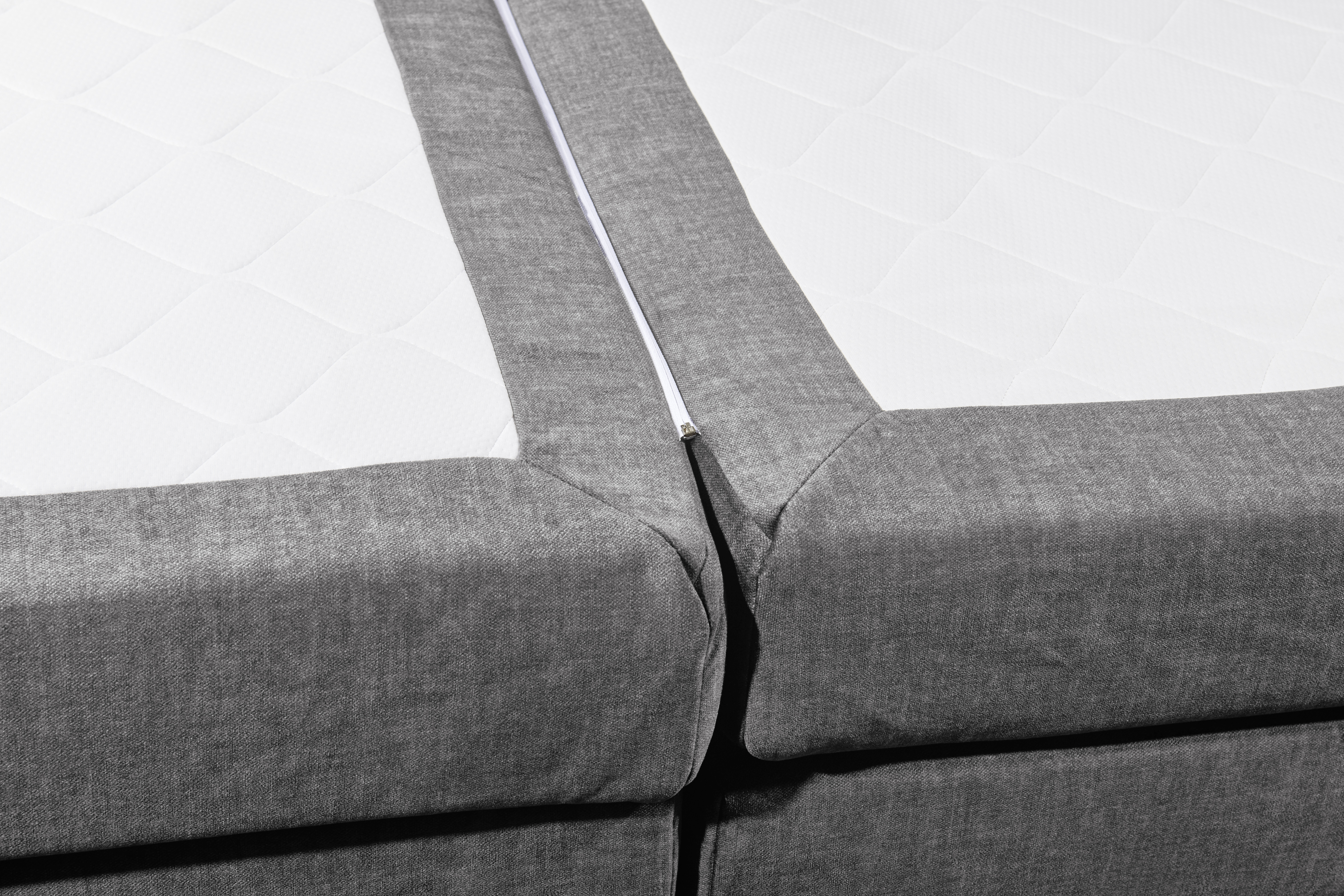 Boxspringbett „Vogue 15 grey“ schräg aufgenommen, Fokus auf die Tonnentaschenfederkern-Matratze, Detail der Liegefläche sichtbar
