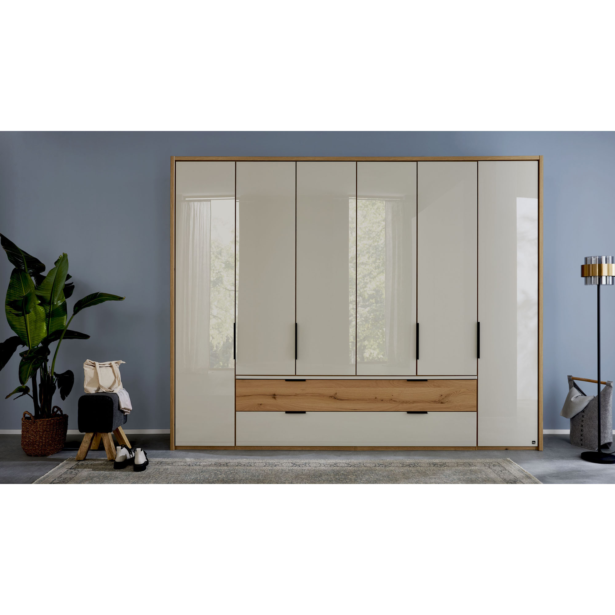 Großer Kleiderschrank Interliving 1034 mit mehreren Drehtüren, Schubladen und Rahmen in Holzoptik in einem Schlafzimmer