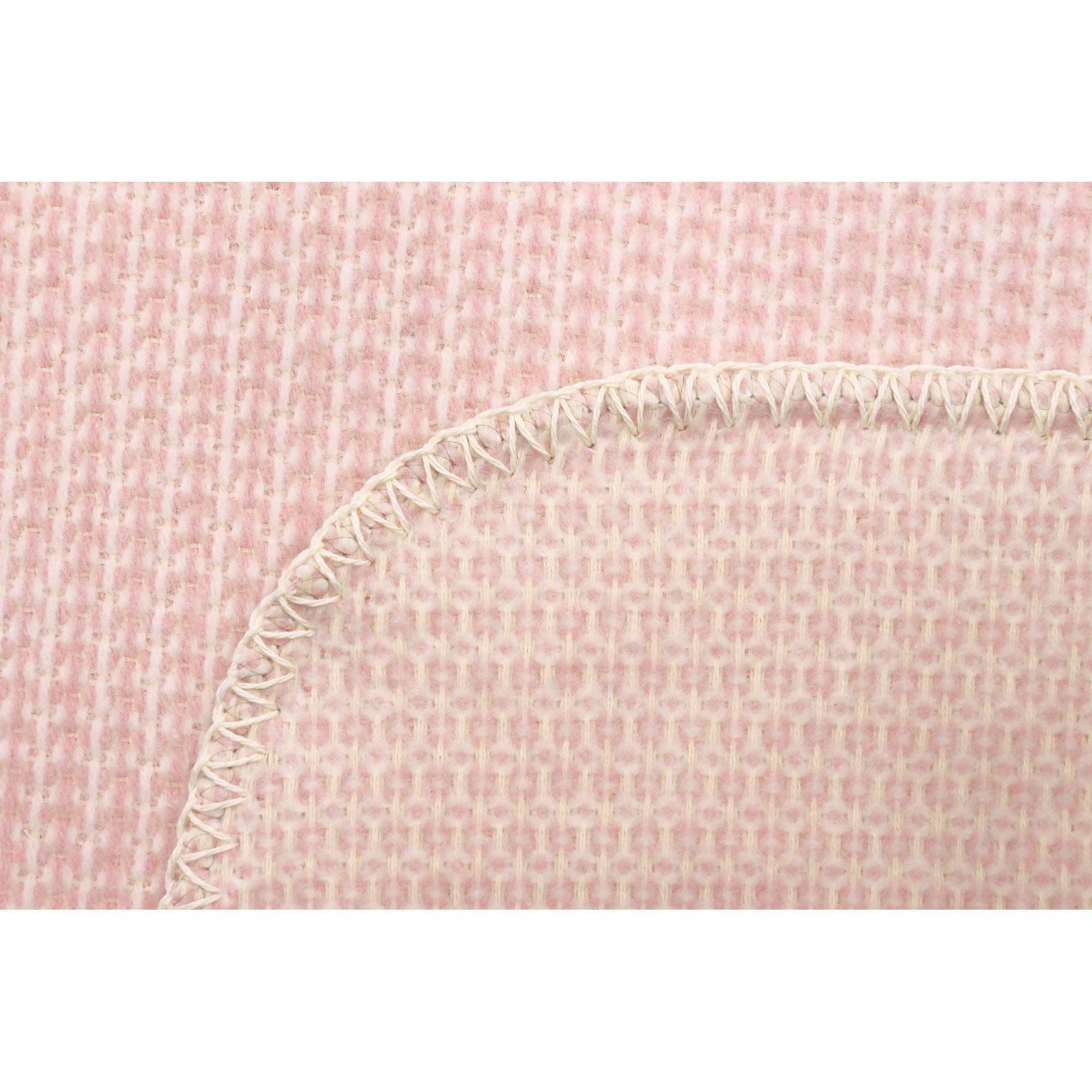 Nahaufnahme der Babydecke Cotton rose mit abgerundeter Ecke, heller Einfassung und fein gewebter Struktur.