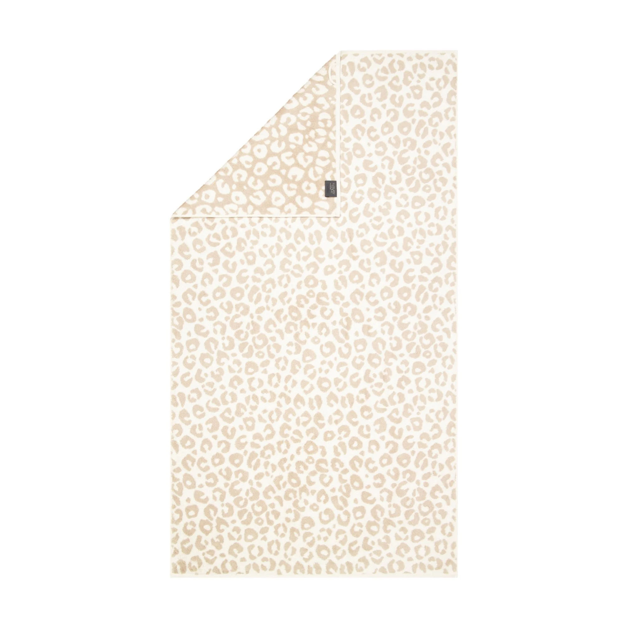 Duschtuch in der Farbe Natur mit beigefarbenem Leopardenmuster auf hellem Grund und umgeschlagener Ecke; Vorderseite, Rückseite und kleines Textiletikett sind sichtbar.