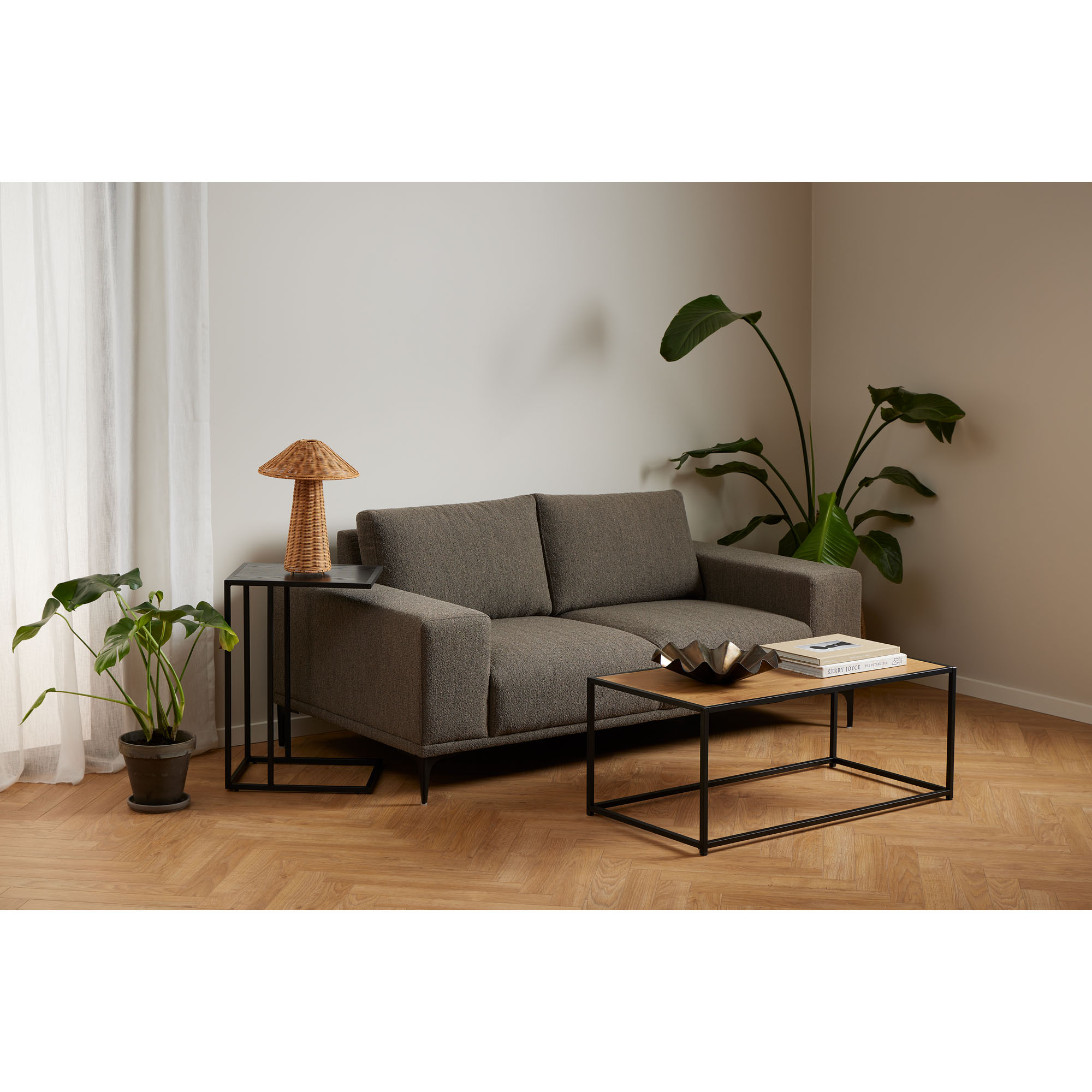 Couchtisch mit Platte in Wildeiche und mattschwarzem Gestell in einem eingerichteten Wohnzimmer, dekoriert mit Schale und Büchern