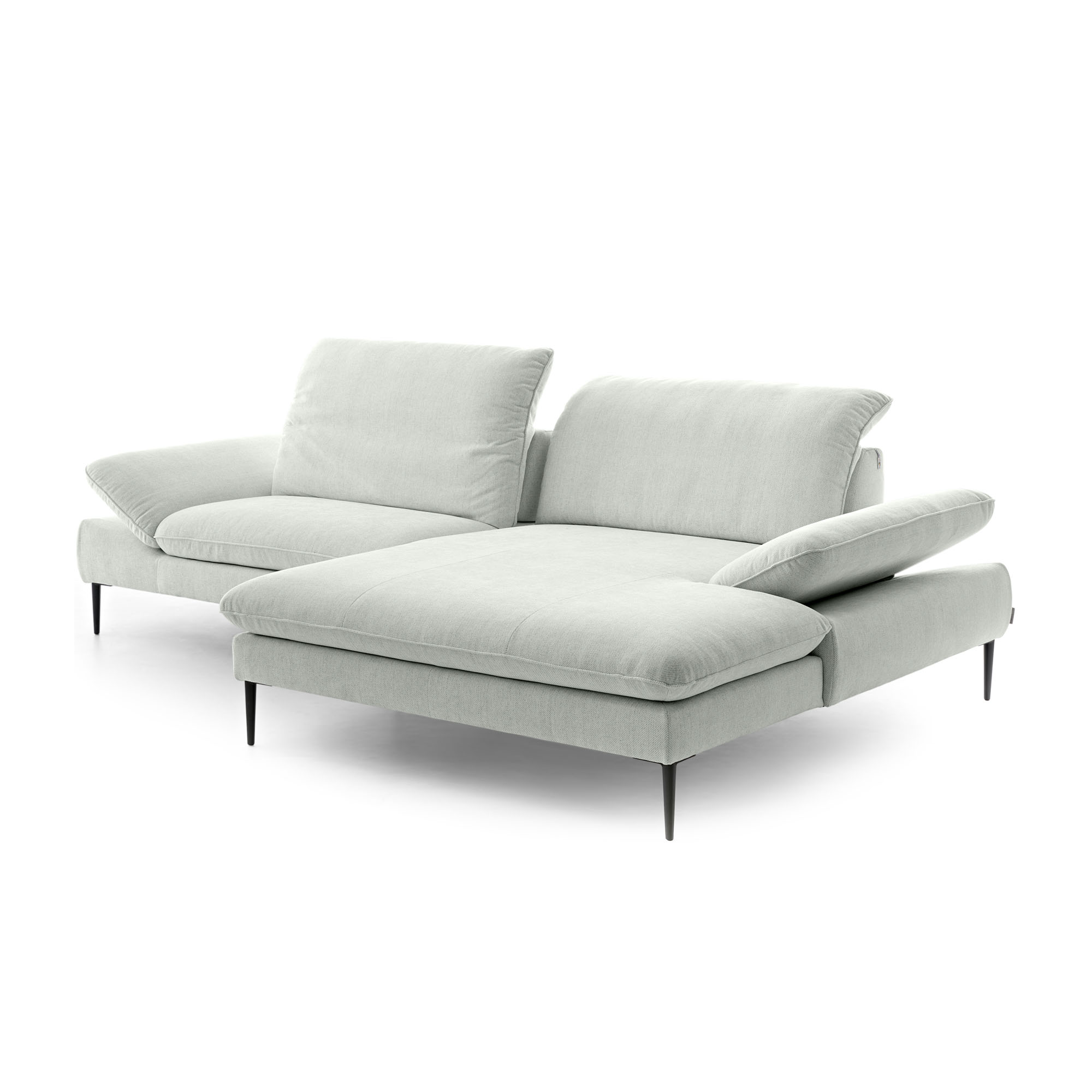 Freigestellte Polstergarnitur in Light Grey mit Ottomane, mehreren Rückenkissen und unterschiedlich ausgerichteten Rückenlehnen