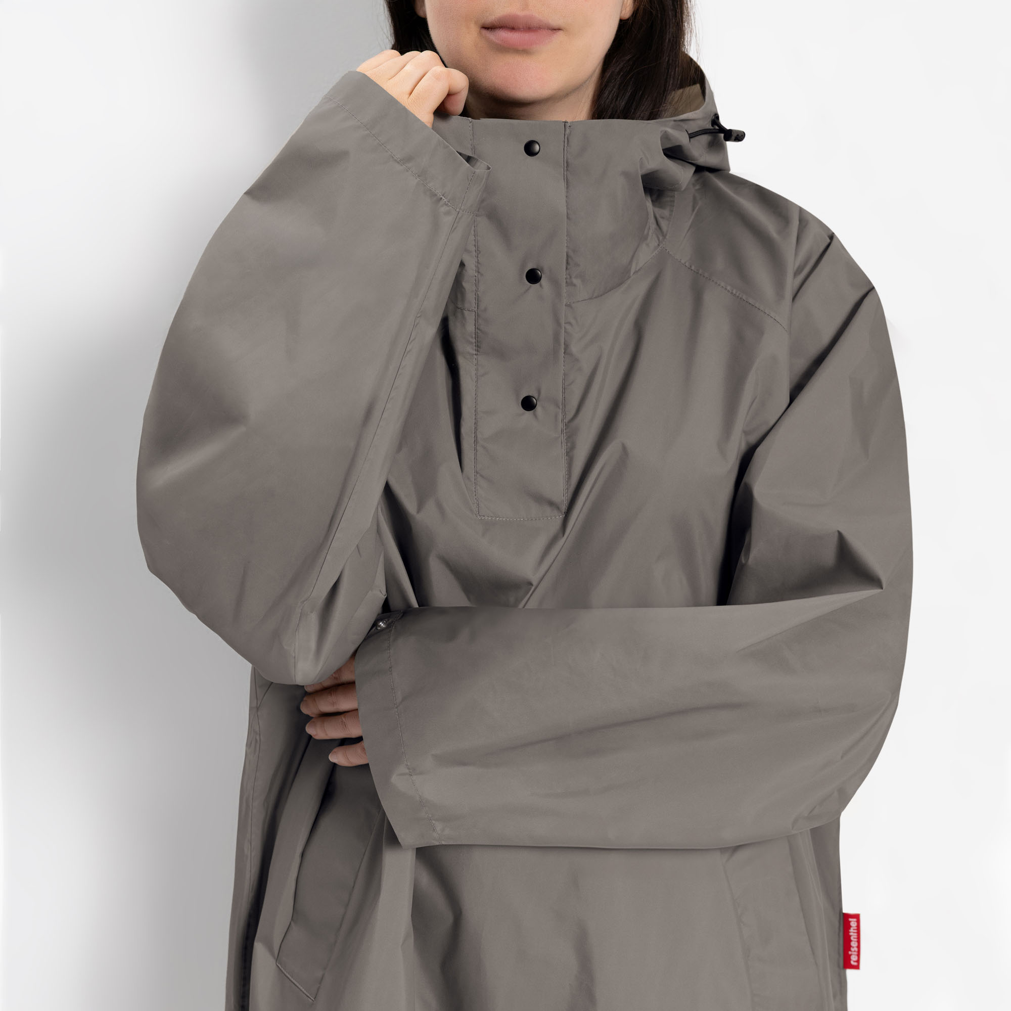 Detailaufnahme des hohen Kragens und der Kapuze des grauen Regenponchos