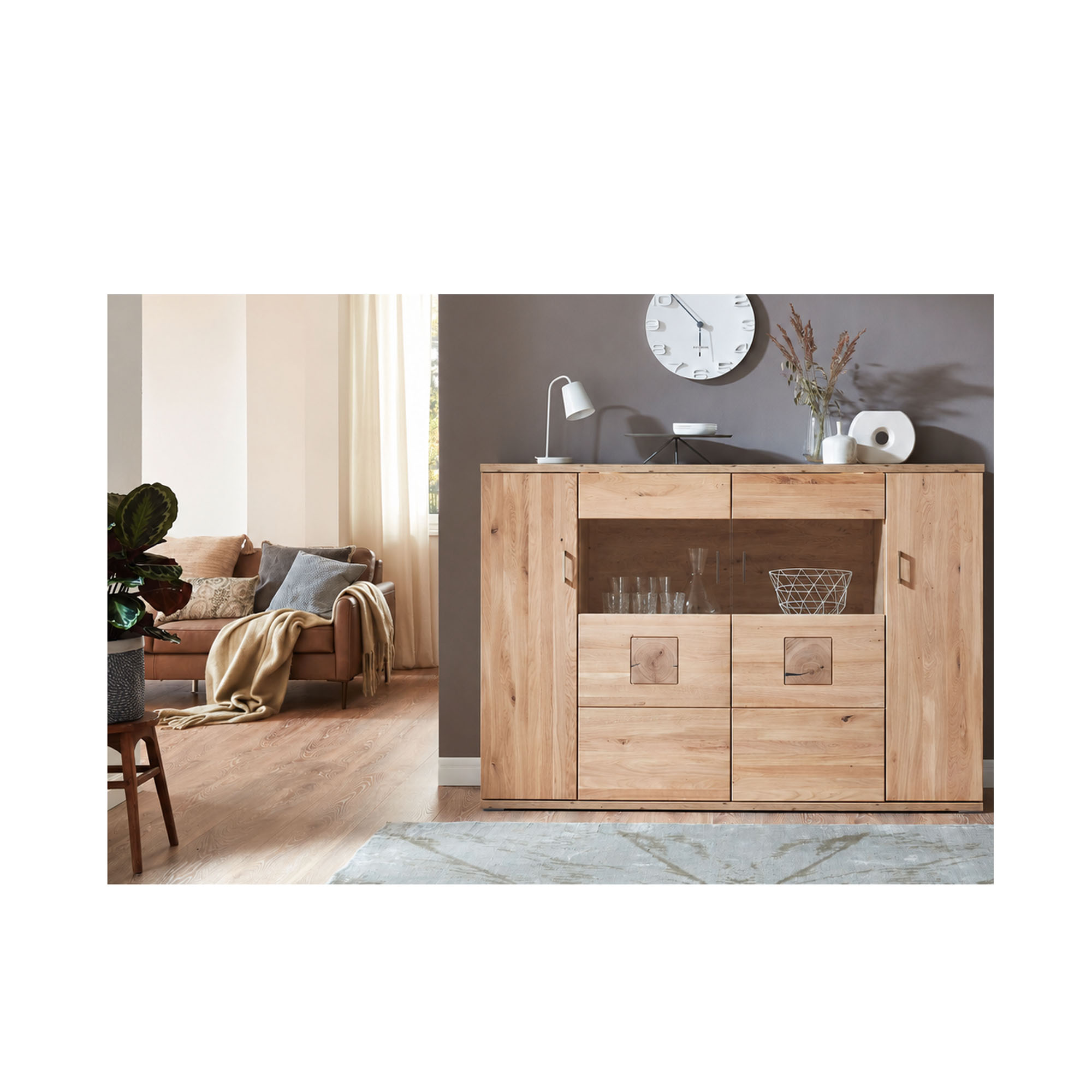 Highboard in Holzoptik vor einer hellen Wand mit Dekoration und angrenzender Sitzgruppe