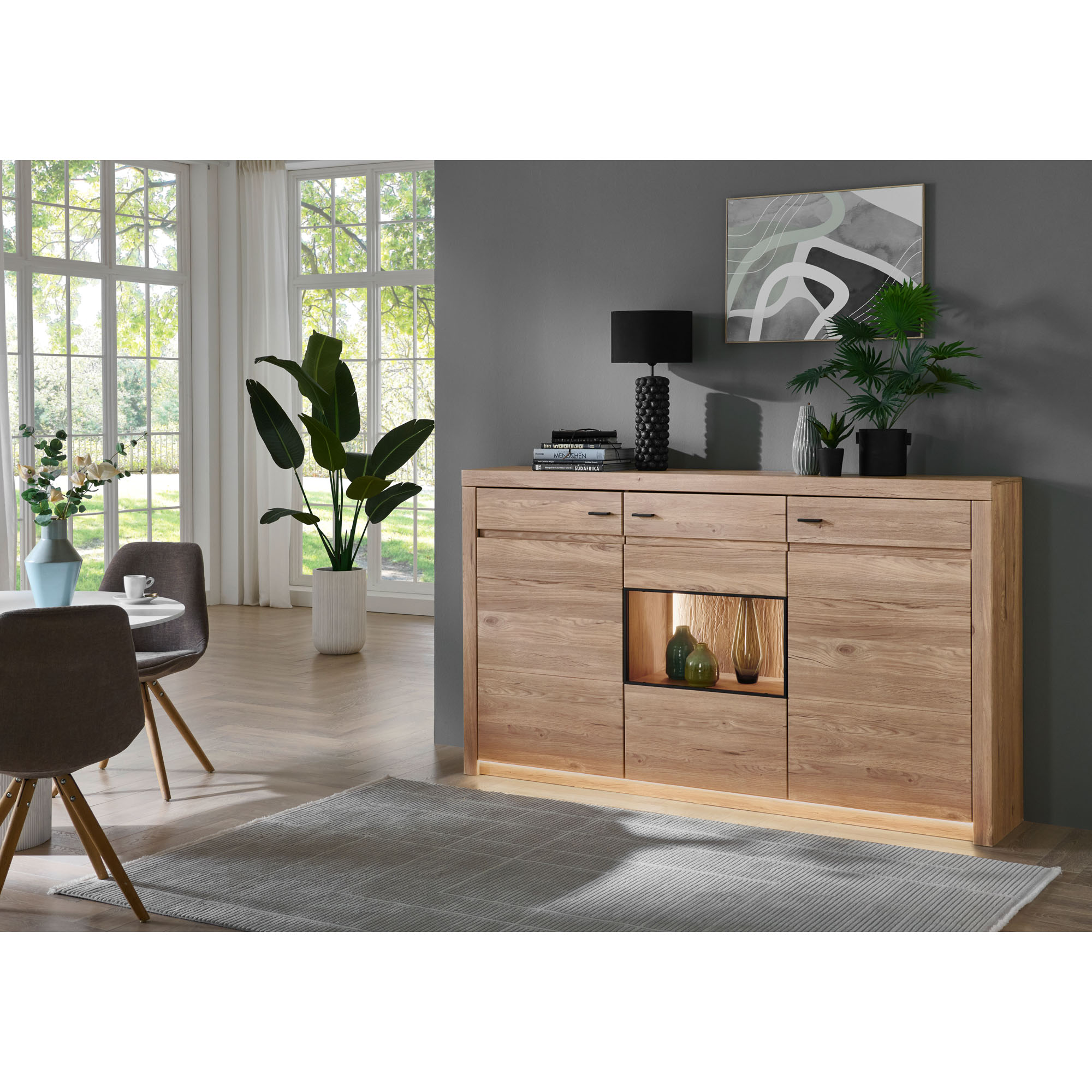 Sideboard in Holzoptik vor einer grauen Wand mit Pflanzen Bildern und weiteren Wohnaccessoires
