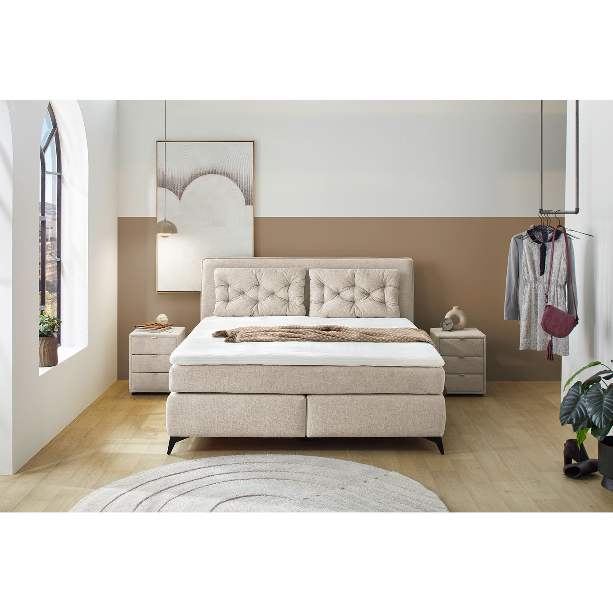 Boxspringbett mit Liegefläche 180×200 cm in Beige, dargestellt in einem Milieubild in einem Schlafzimmer