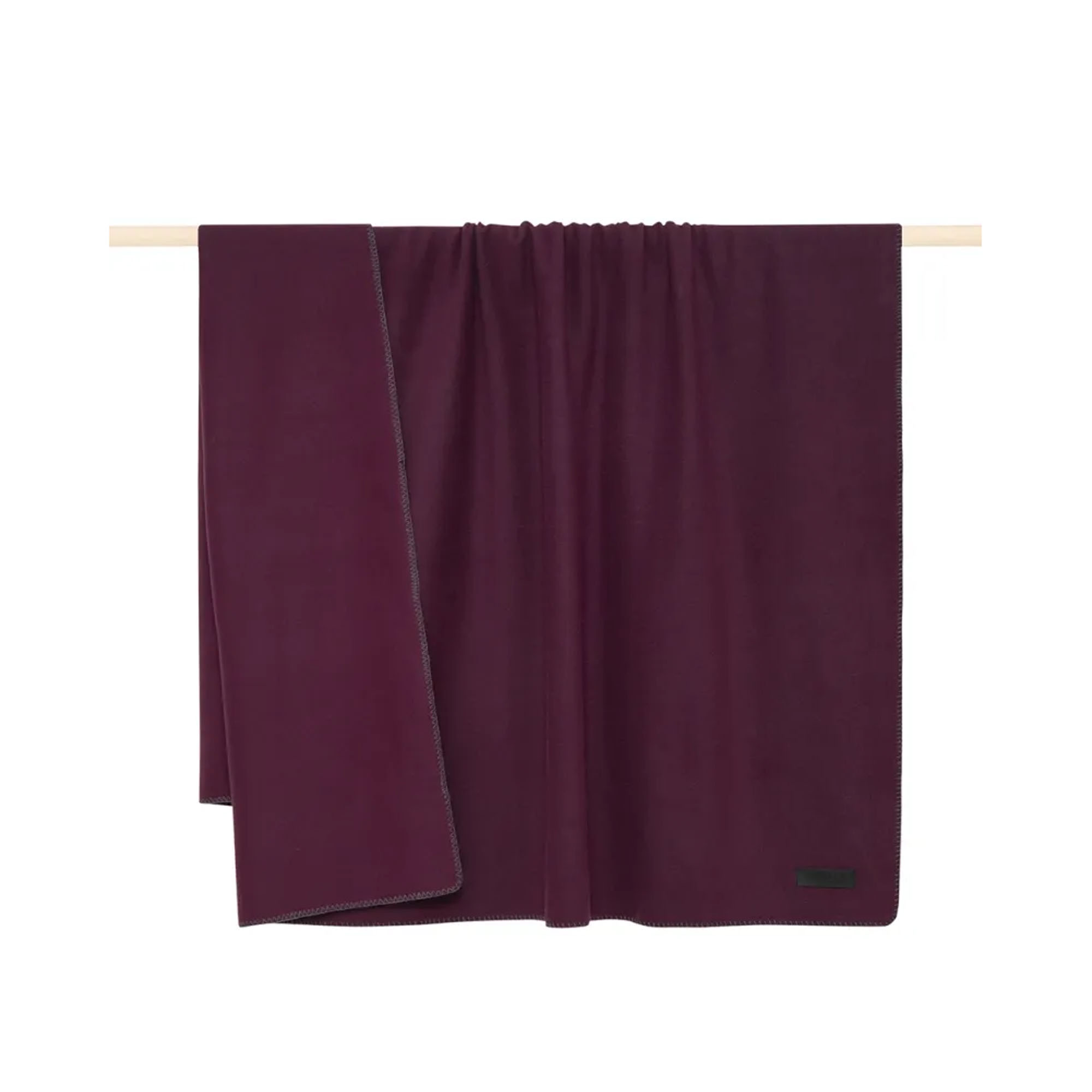 Decke Proflax Fleece in Bordeaux, 160 × 200 cm, sauber gefaltet mit sichtbarer Ziernaht am Rand und kleinem Textillabel.