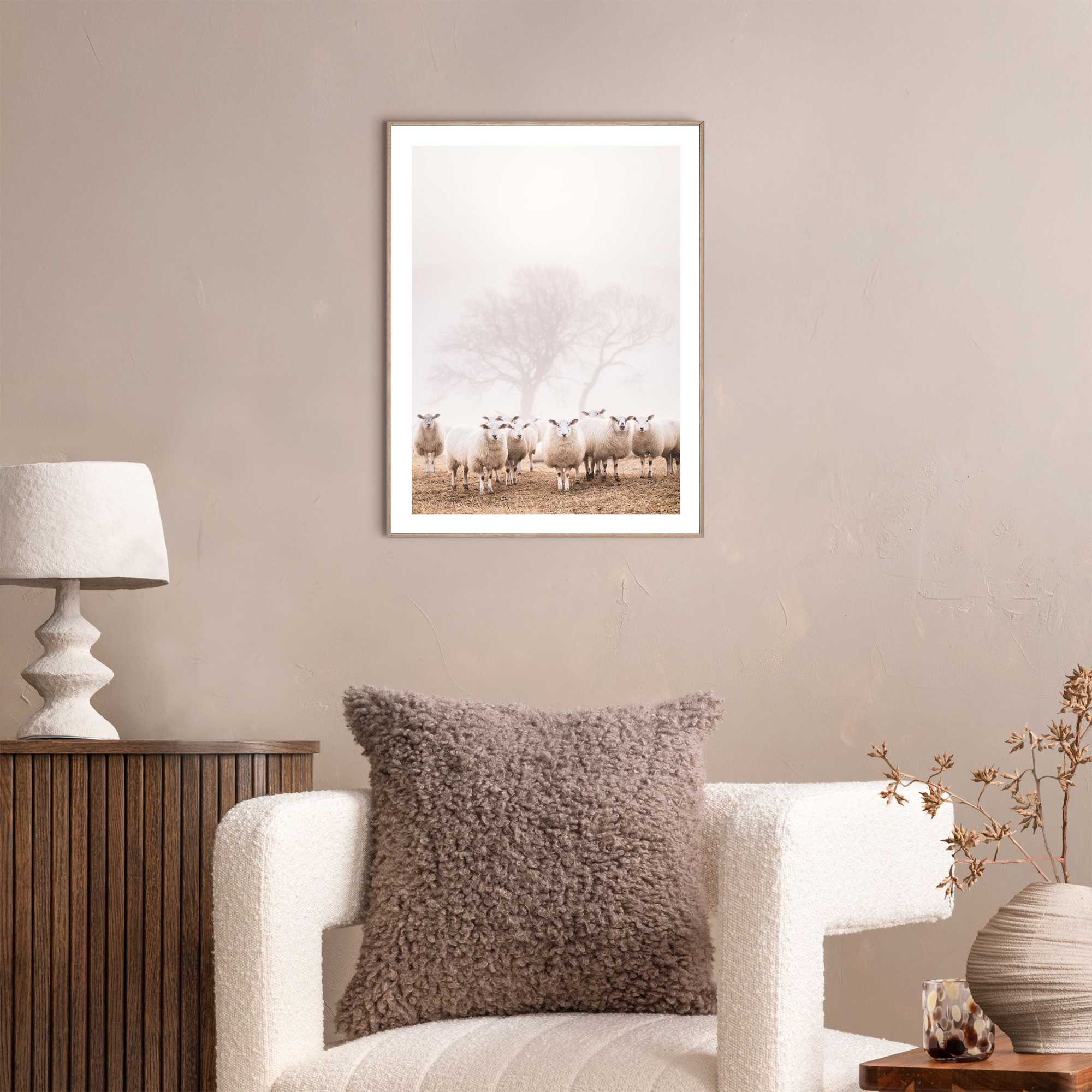 Das Wandbild „Sheep in Field“ in Beige, 30 × 40 cm, hängt in einem eingerichteten Wohnraum und zeigt die Größenwirkung an der Wand.