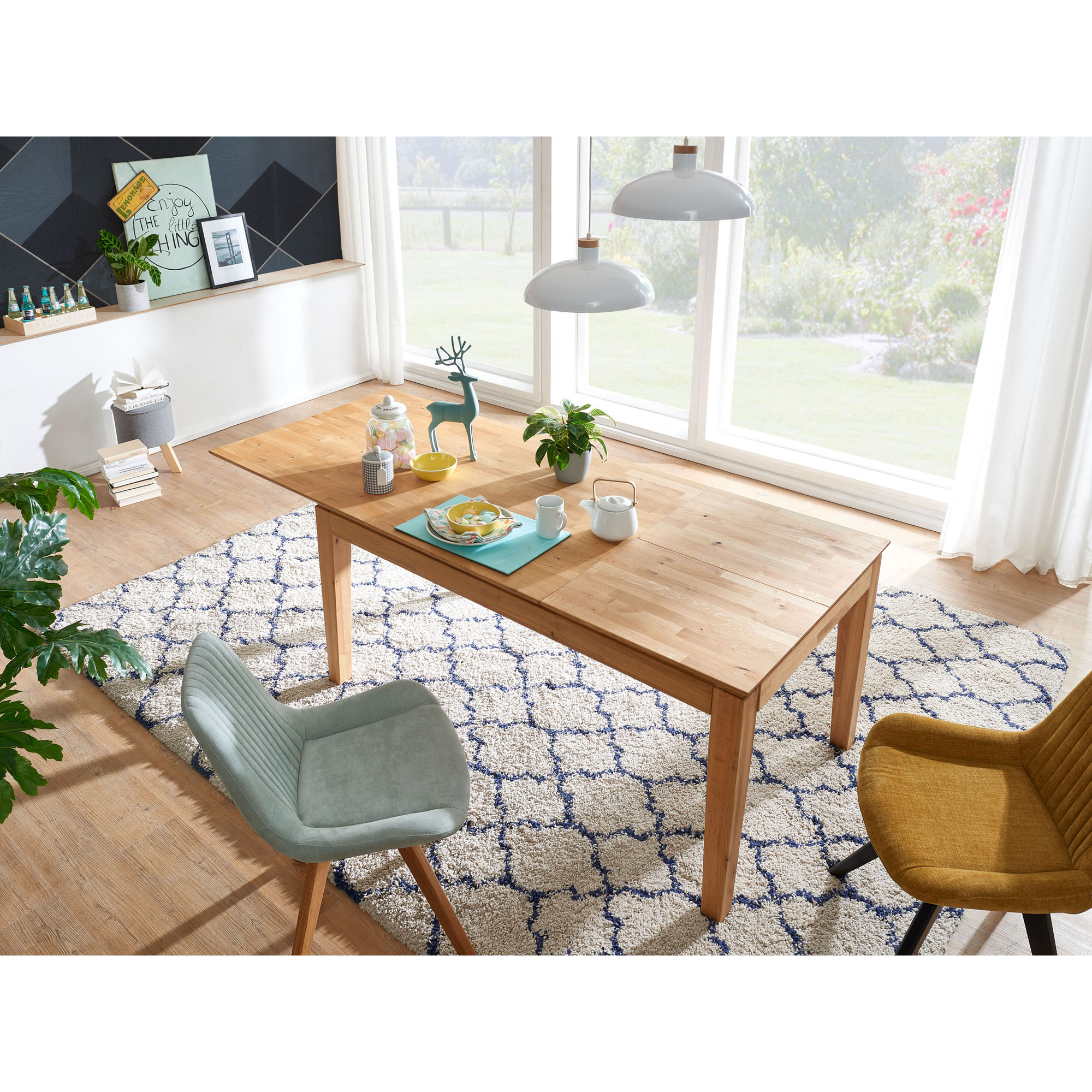 Ausziehbarer Esstisch aus Holz in einem Esszimmer mit Teppich, Stühlen und großen Fenstern