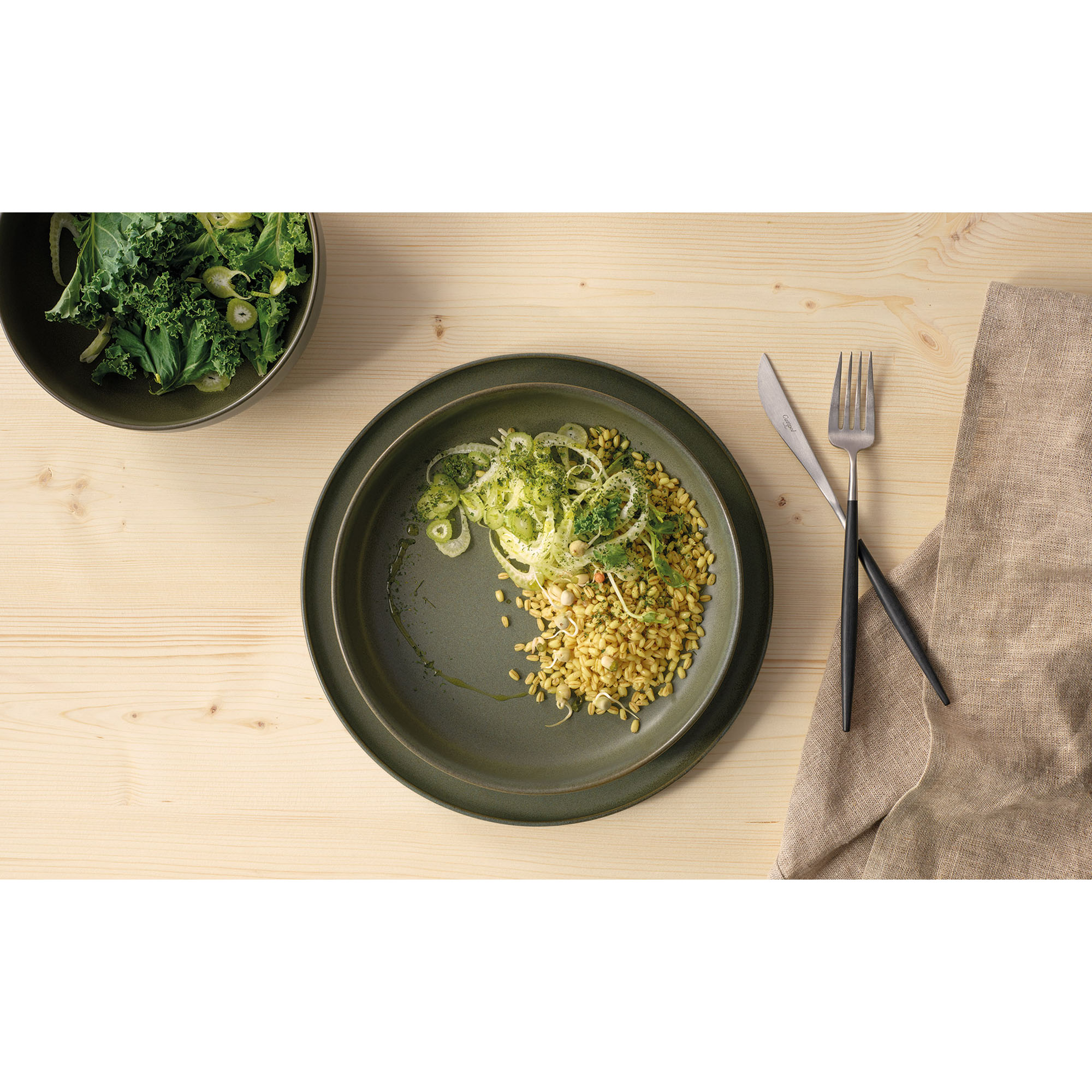 Gourmetteller der Serie Coppa, Farbe Grün in einer gedeckten Tischszene mit weiterem Geschirr.